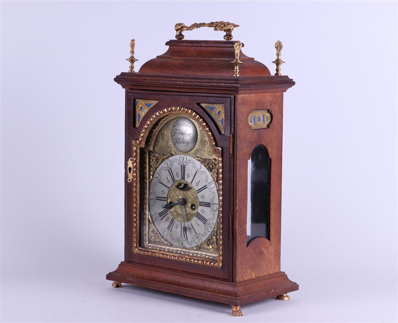 Null An Austrian table clock in an oak case with bronze mounts. Address: "Heiner&hellip;