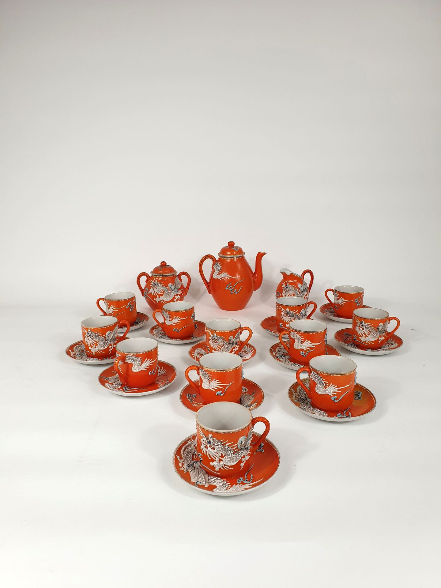 Null 橙色背景的龙纹茶具，包括十二个杯和碟，一个壶，一个牛奶壶和一个有盖糖碗
日本，萨摩，20世纪
(牛奶壶的壶嘴已经损坏，糖碗的盖子已经粘回去了，装饰已经&hellip;