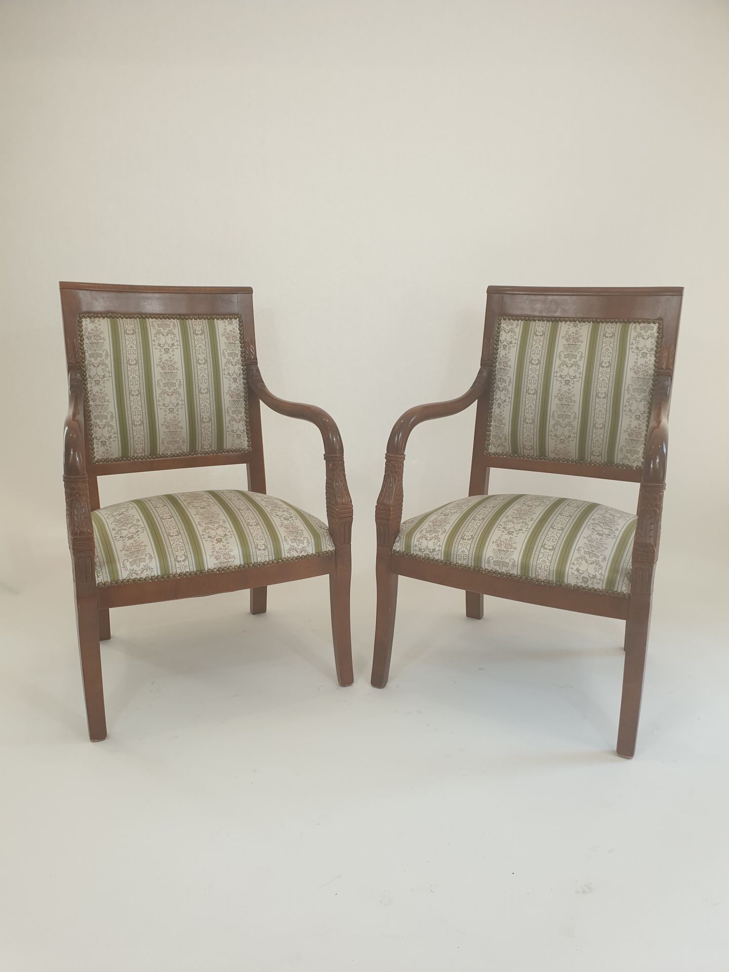 Null 一对着色的天然木扶手椅，有直的靠背和扶手，上面雕刻着树叶。
帝国风格，20世纪
90 x 57 x 50厘米
(小事故和缺失的部分)