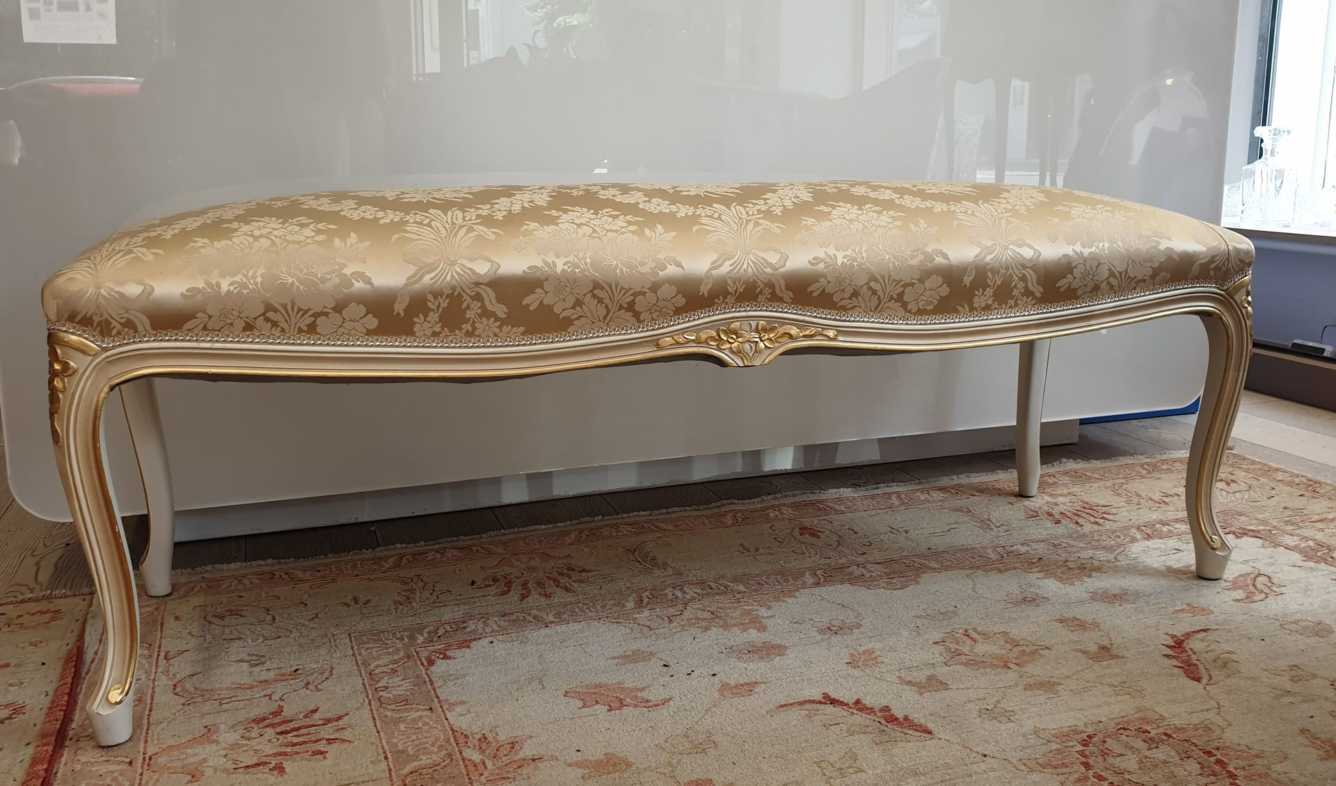 Null 奶油和镀金的木质长凳，装饰有花朵，弯曲的腿。
路易十五风格，20世纪
来自皮埃尔-弗雷的沙蚕丝软垫
49 x 143 x 46厘米