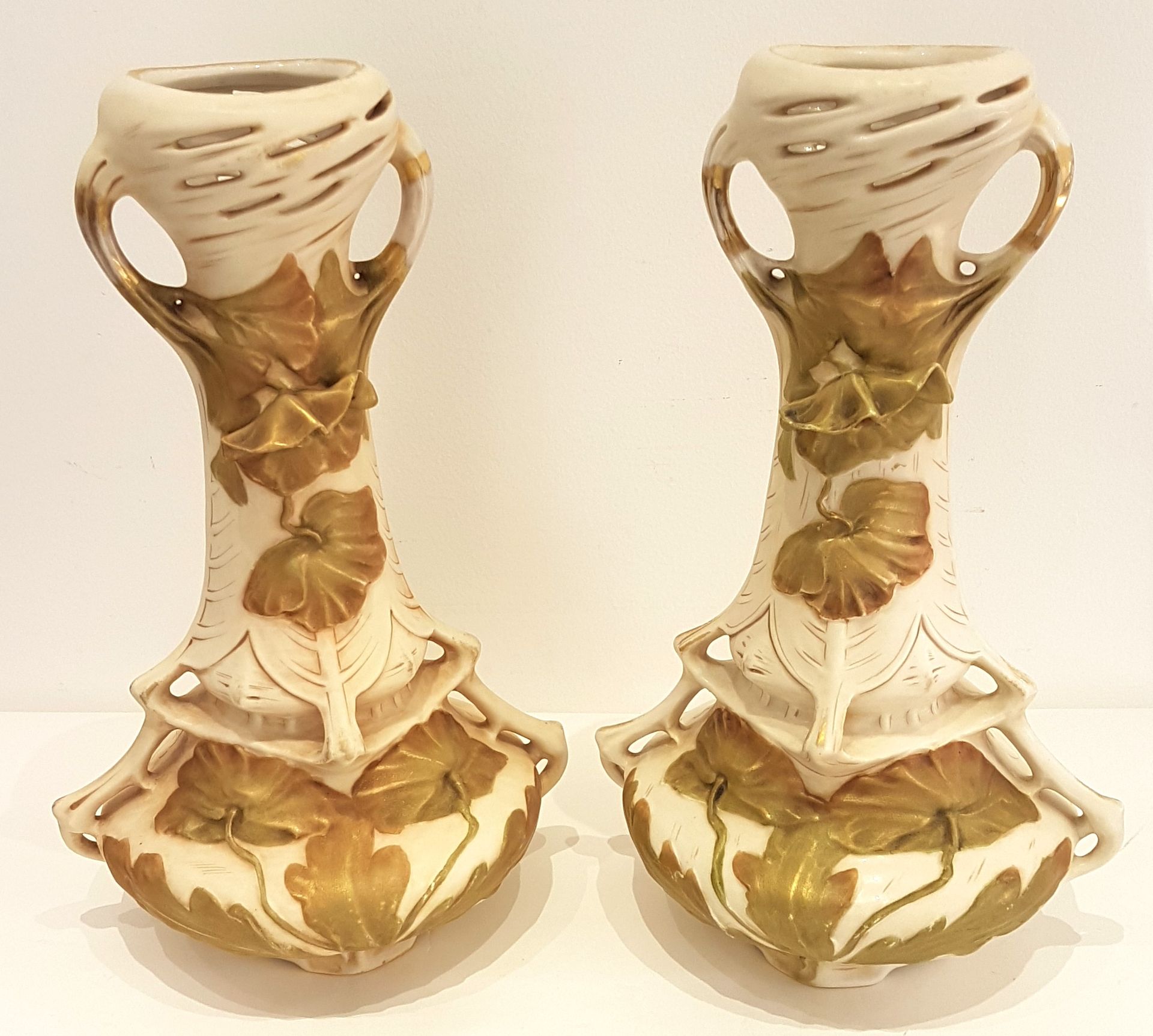 Null ROYAL DUX，一对奶油色模制饼干高颈花瓶，饰以镀金树叶和罂粟花
底部有标记和编号 
约 1900 年
H.34 厘米