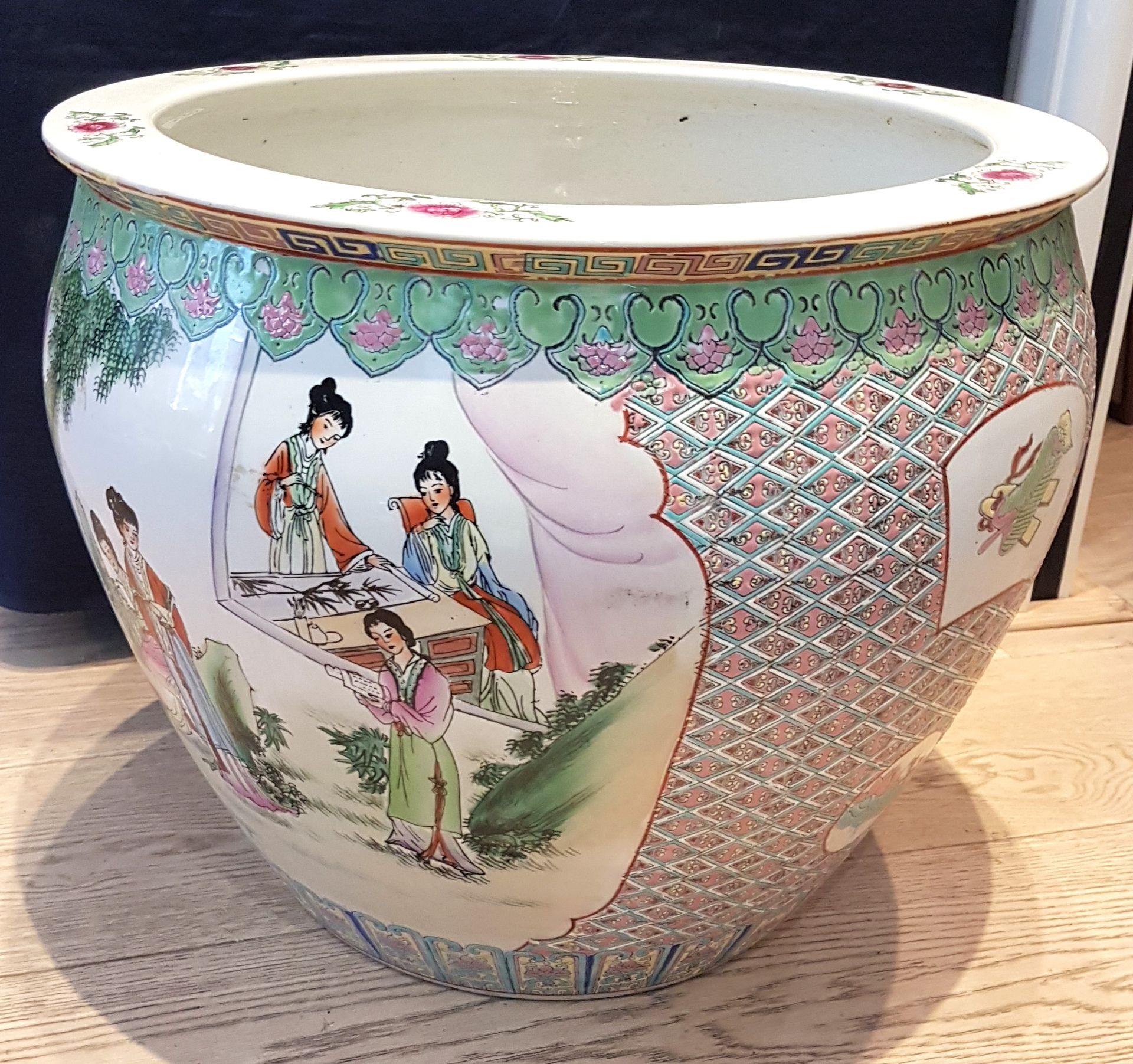 Null 一个大型瓷质储物罐，保留了花格背景上花园中年轻女性的装饰。
内饰金鱼
中国，20 世纪
H.40 厘米，直径 46.5 厘米