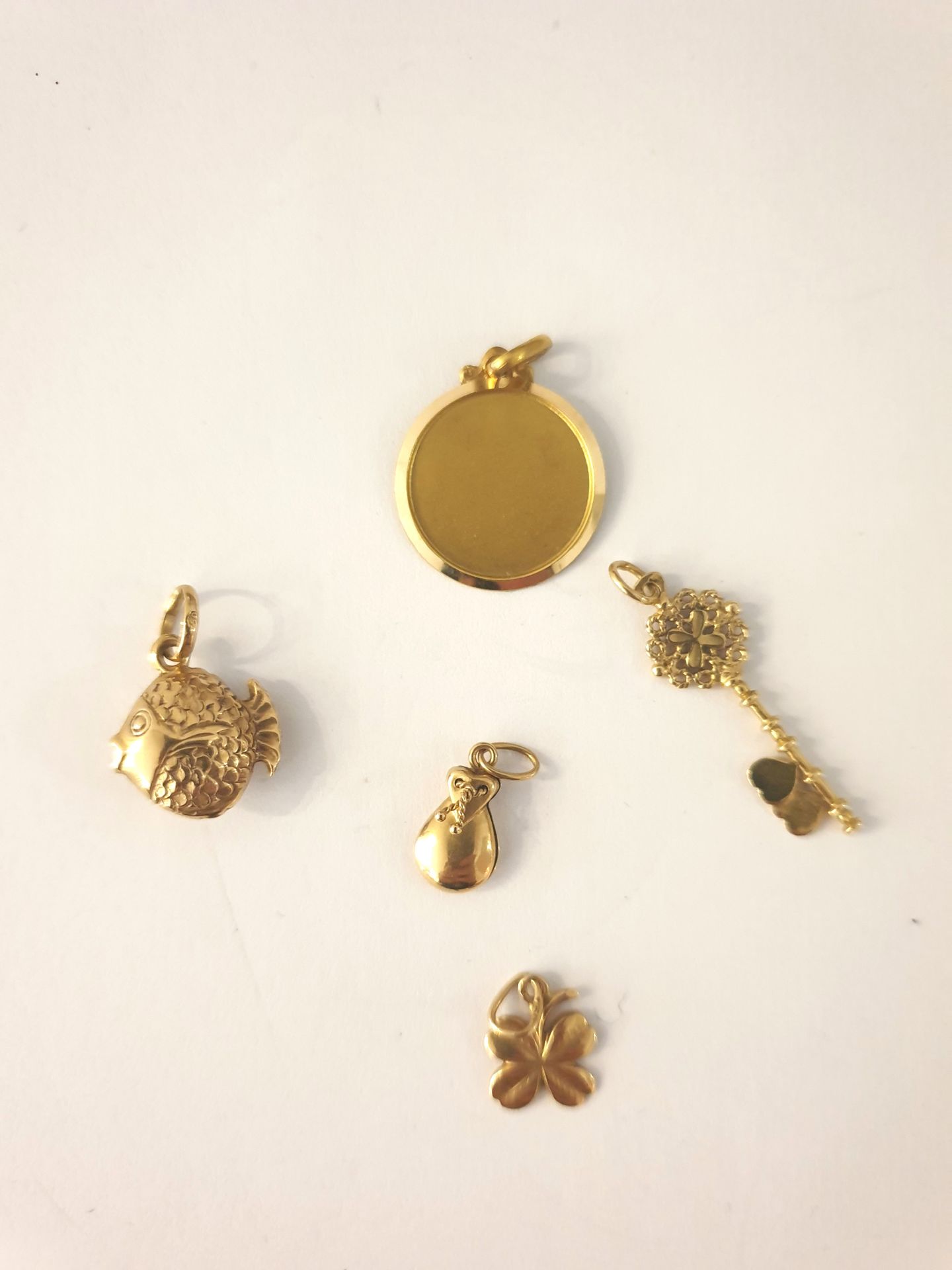 Null Lot de cinq petits pendentifs en or jaune 18k (750‰): 
Trèfle - Clé - médai&hellip;
