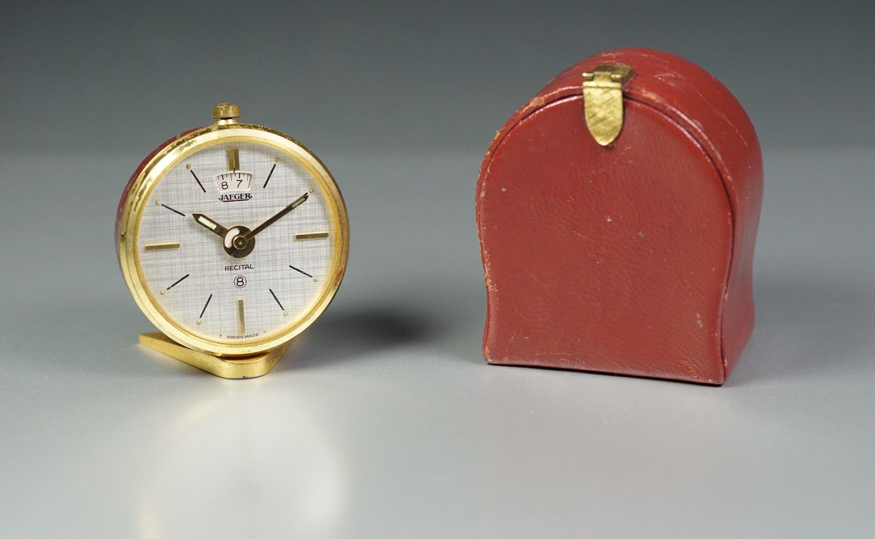 JAEGER 鎏金金属和红色漆面的小型旅行闹钟，装在箱子里。缺少漆面。