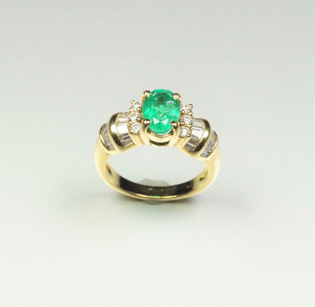 Null 一枚18K（750/oo）金戒指，镶嵌着一颗椭圆形的祖母绿，周围是明亮式切割、锥形切割和长方形切割的钻石。TDD 54. 毛重：6.8克。