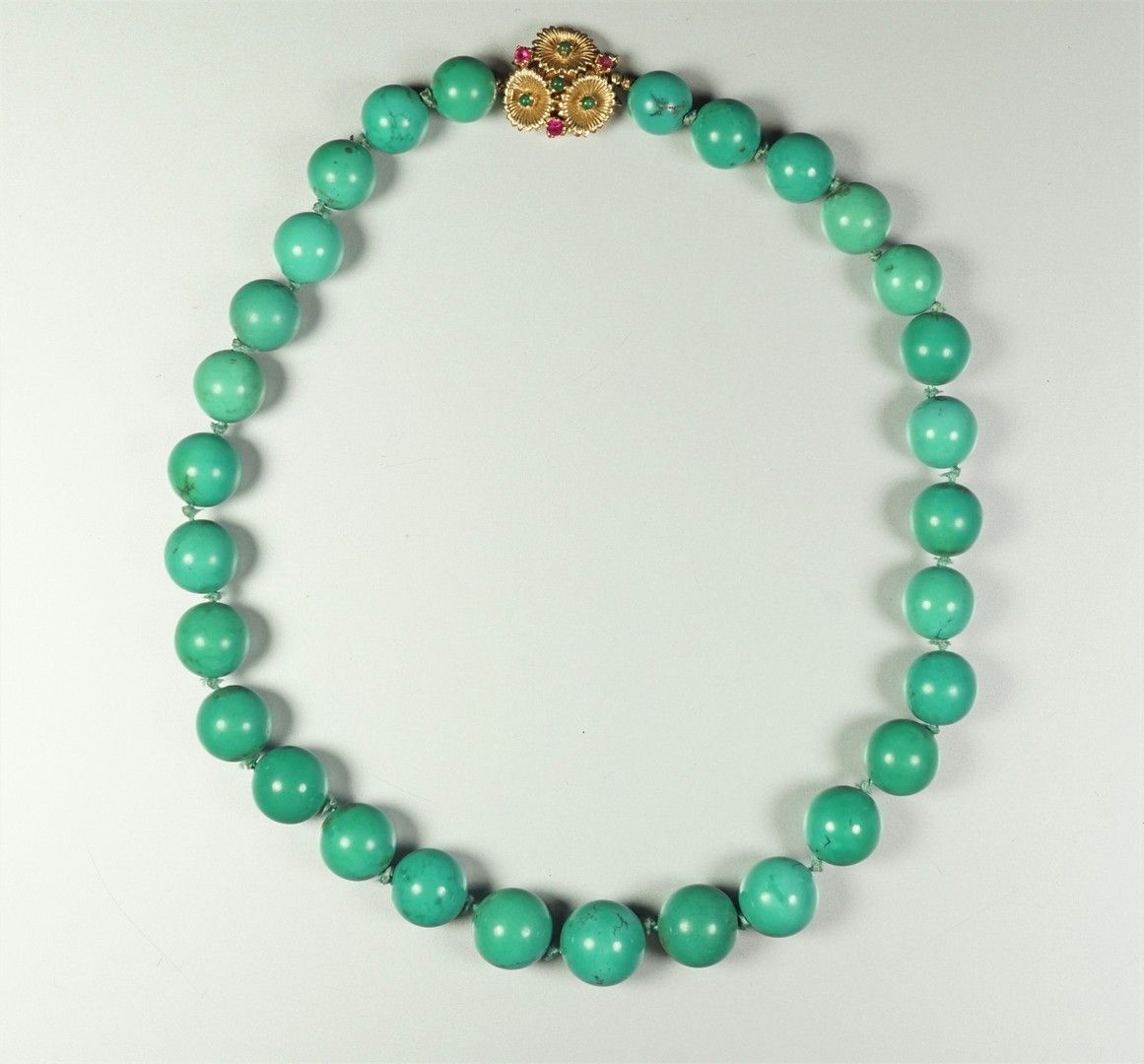Null 由绿松石球组成的项链，14K金（585千分之一）的扣子上镶嵌着红色和绿色的宝石。毛重81.1grs。