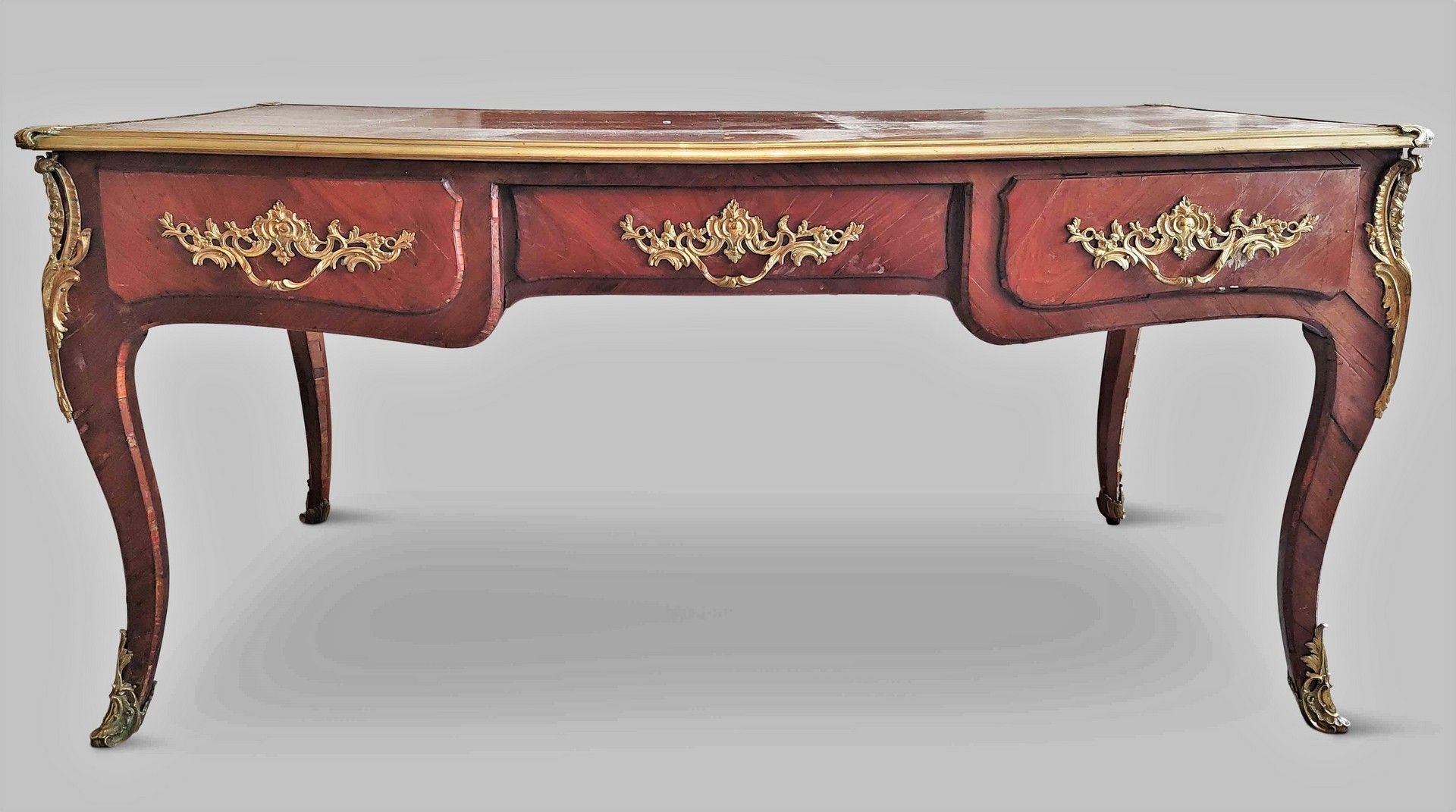 Null 
饰面和丰富的青铜装饰品的平面书桌，在腰部开有三个抽屉。黄褐色的皮革顶部。路易十五时期的作品。 78 x 158 x 78厘米