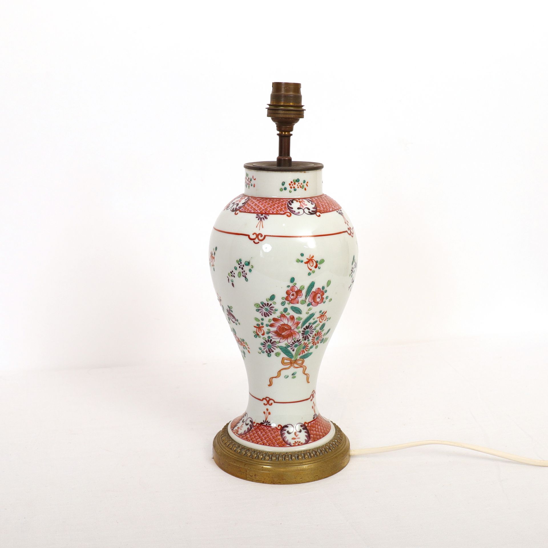 Null 玫瑰花瓶，中国

瓷器上的多色珐琅彩，封面为花束和几何楣饰

中国。清朝时期。18世纪

高：33厘米

底部的鎏金青铜安装，并安装成一盏灯