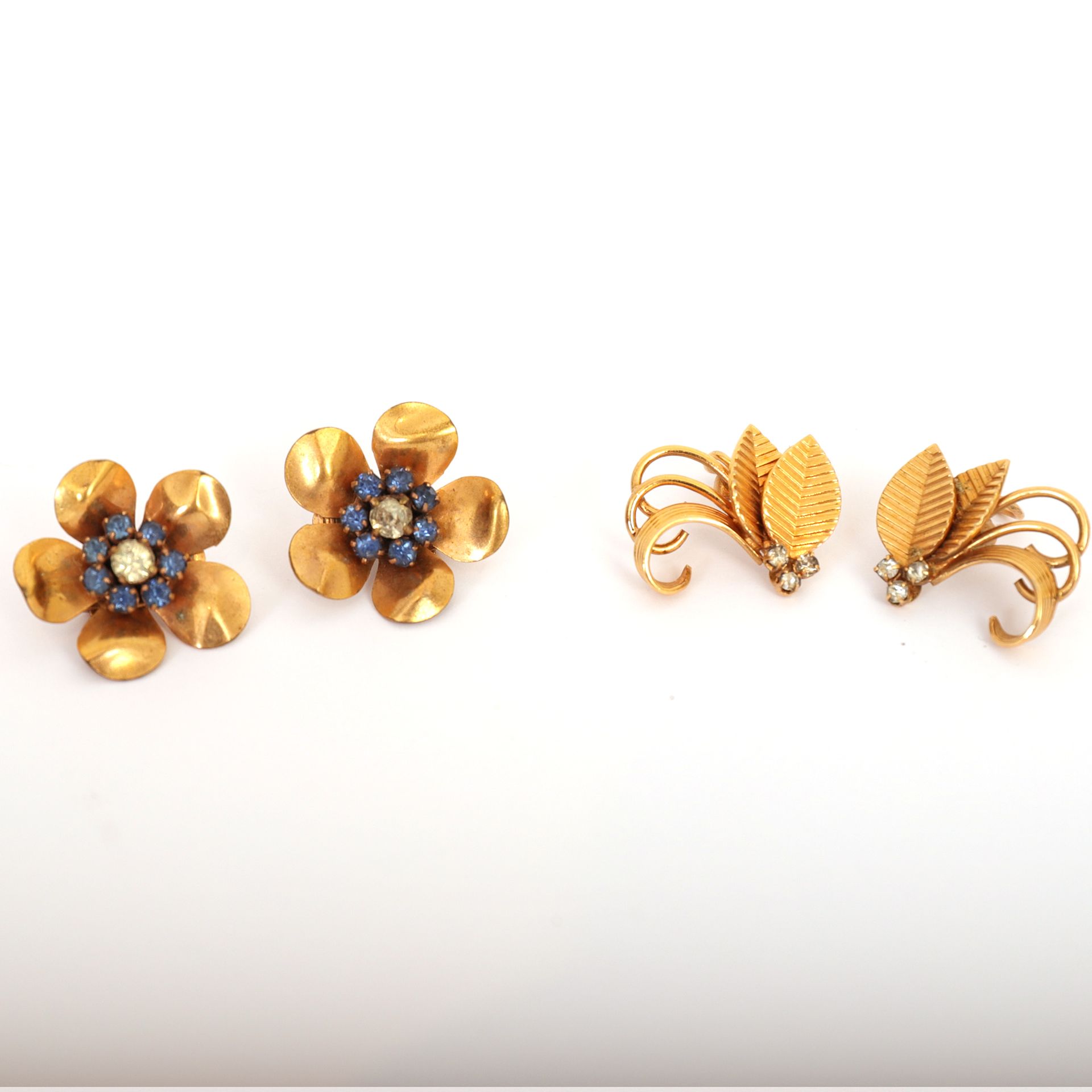 Null 两对花式耳夹

其中一个代表五瓣花，中间有七颗蓝宝石，围绕着一个明亮的

另一个代表两片由三颗钻石和一系列耳环连接起来的风格化的叶子