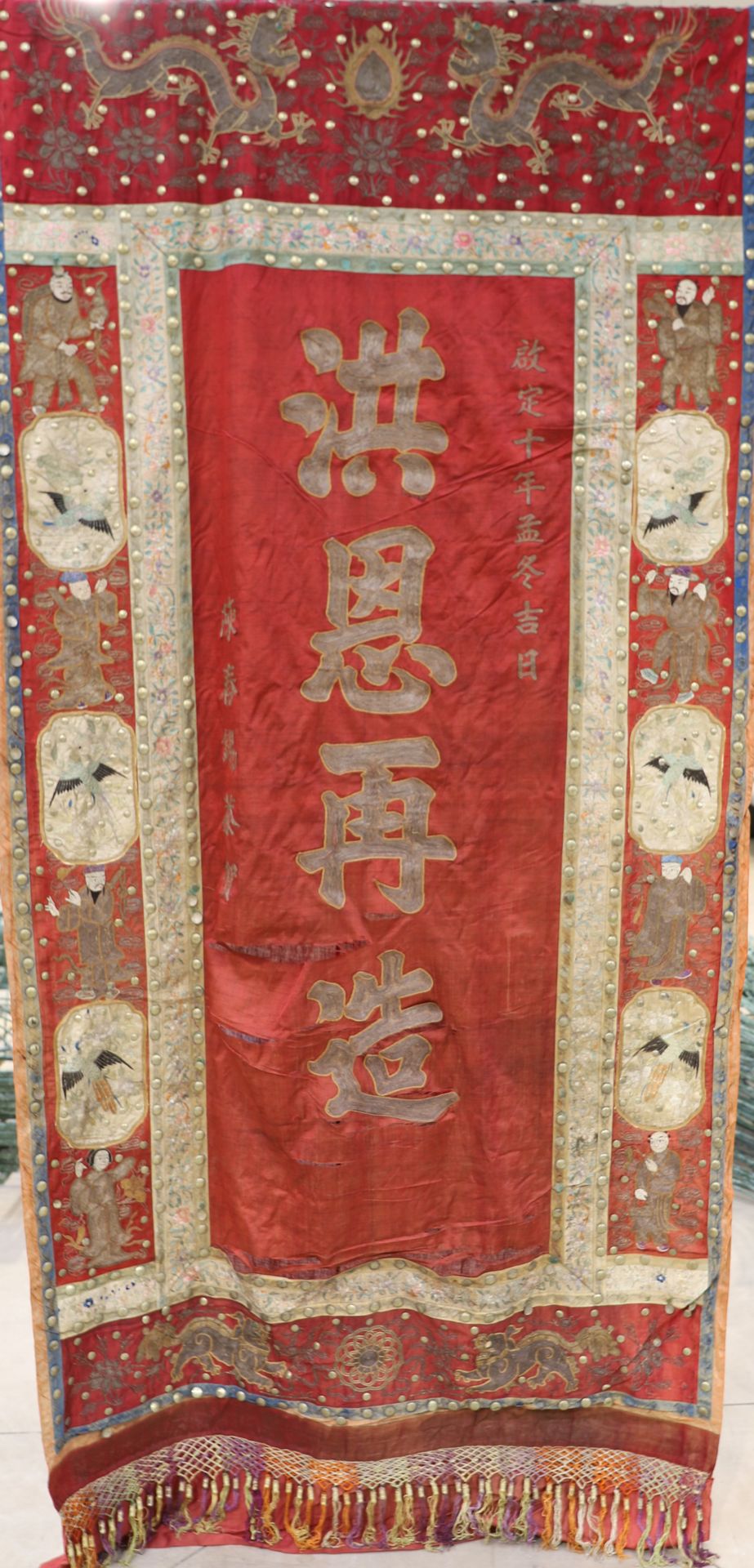 Null 中国丝绸帐篷，铜纽扣和银线编织的装饰，中央是汉字的红底，上边框是相向的帝王龙，下边框是相向的狗，边框是鸟和人物。

19世纪

272 x 125 c&hellip;