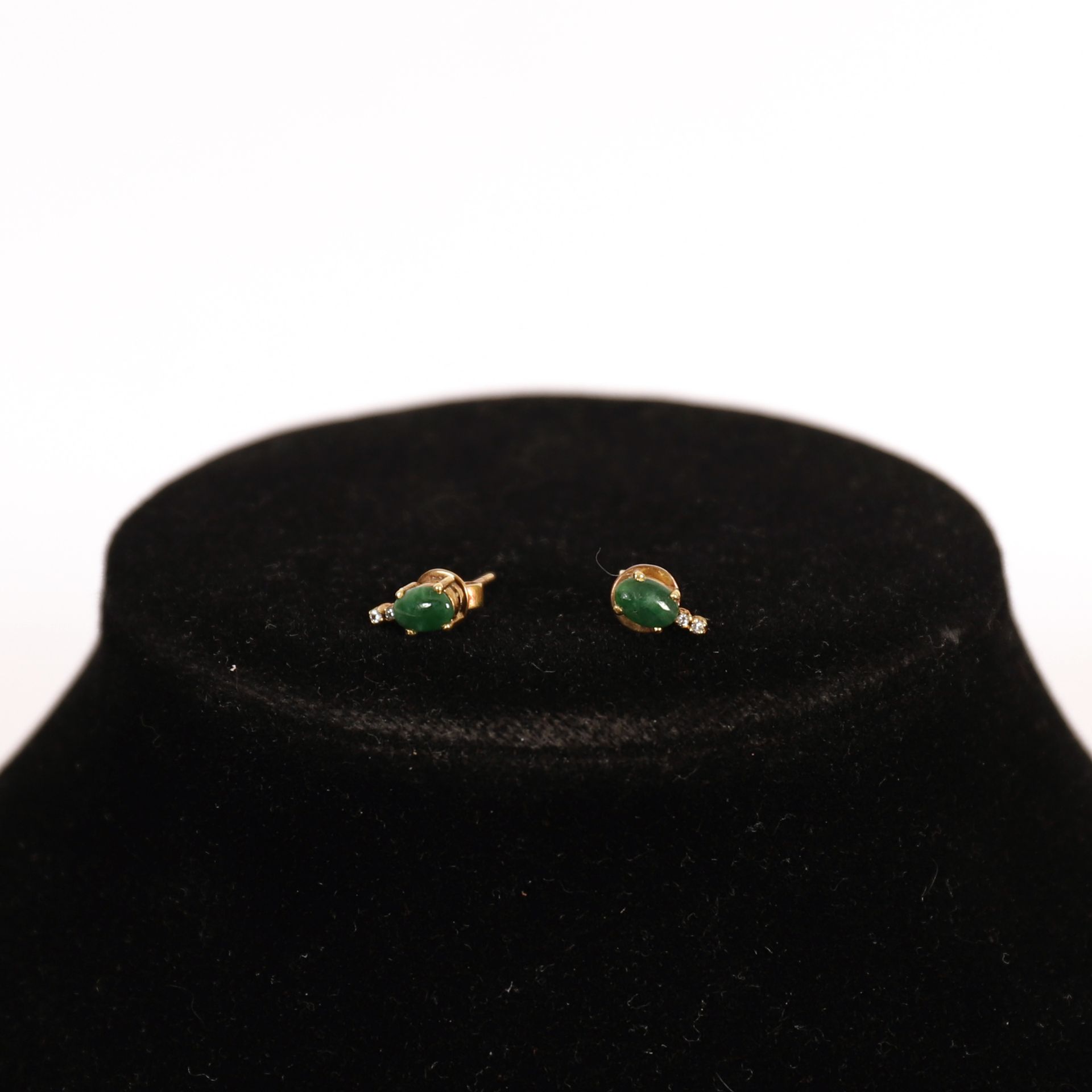 Null 绿宝石耳环一对

镶嵌绿色凸圆形宝石和小钻石的黄金底座

重量：2克左右。
