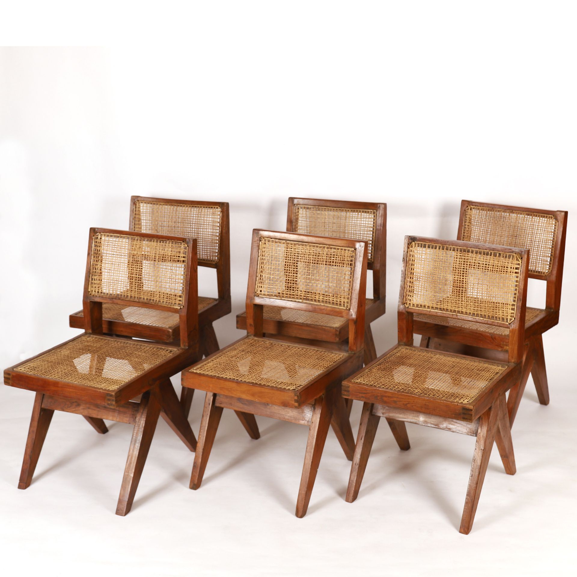 Null 皮埃尔-詹纳利(Pierre Jeanneret) (1896-1967)

非凡的6把 "餐椅 "套装

实心柚木椅子，罗盘式双侧腿由两根支柱连接。&hellip;