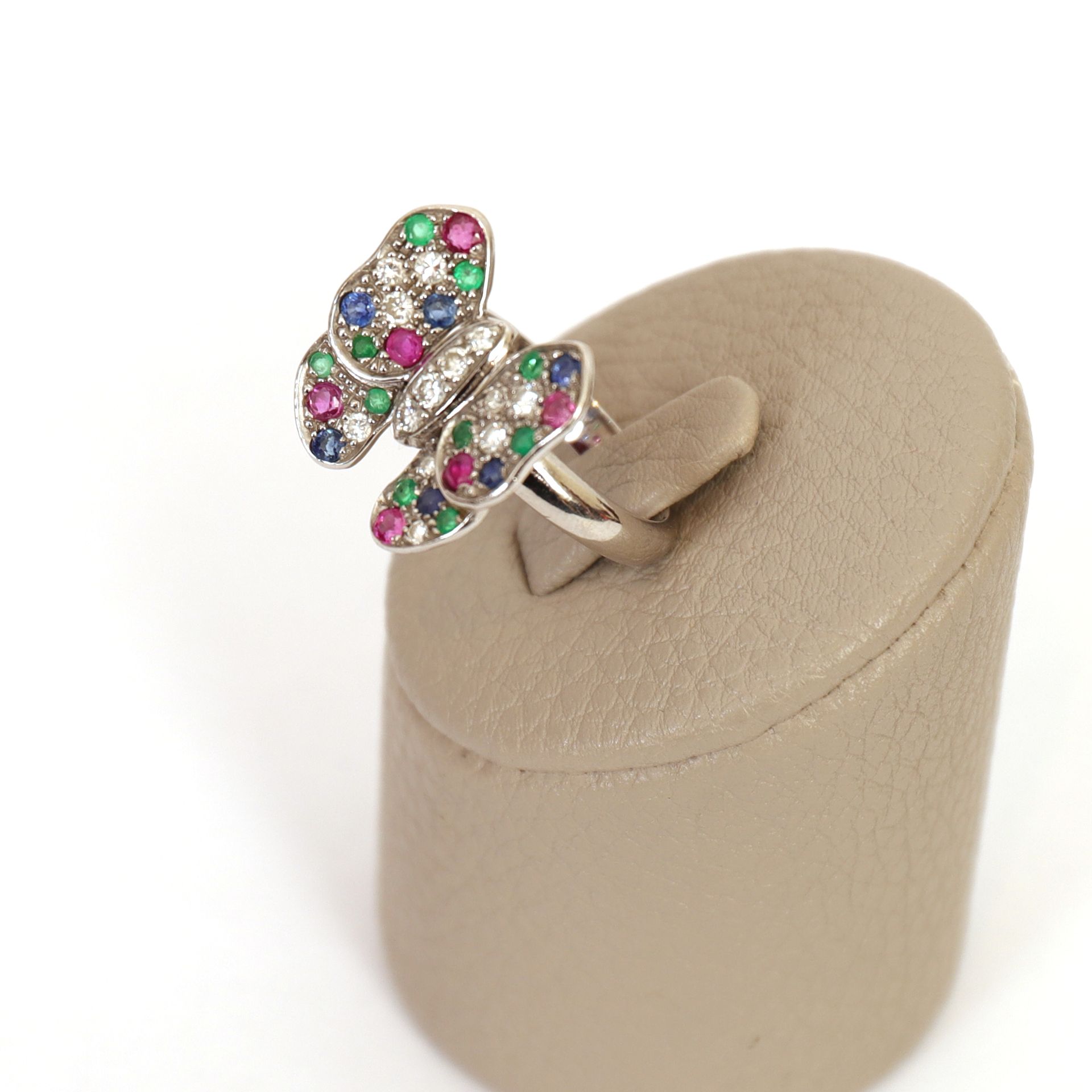 Null 白金蝴蝶戒指

蝴蝶形的表圈上有各种明亮式切割的宝石，包括10颗钻石、10颗绿宝石、6颗蓝宝石和6颗红宝石。

20世纪时期

Pb : 10 grs