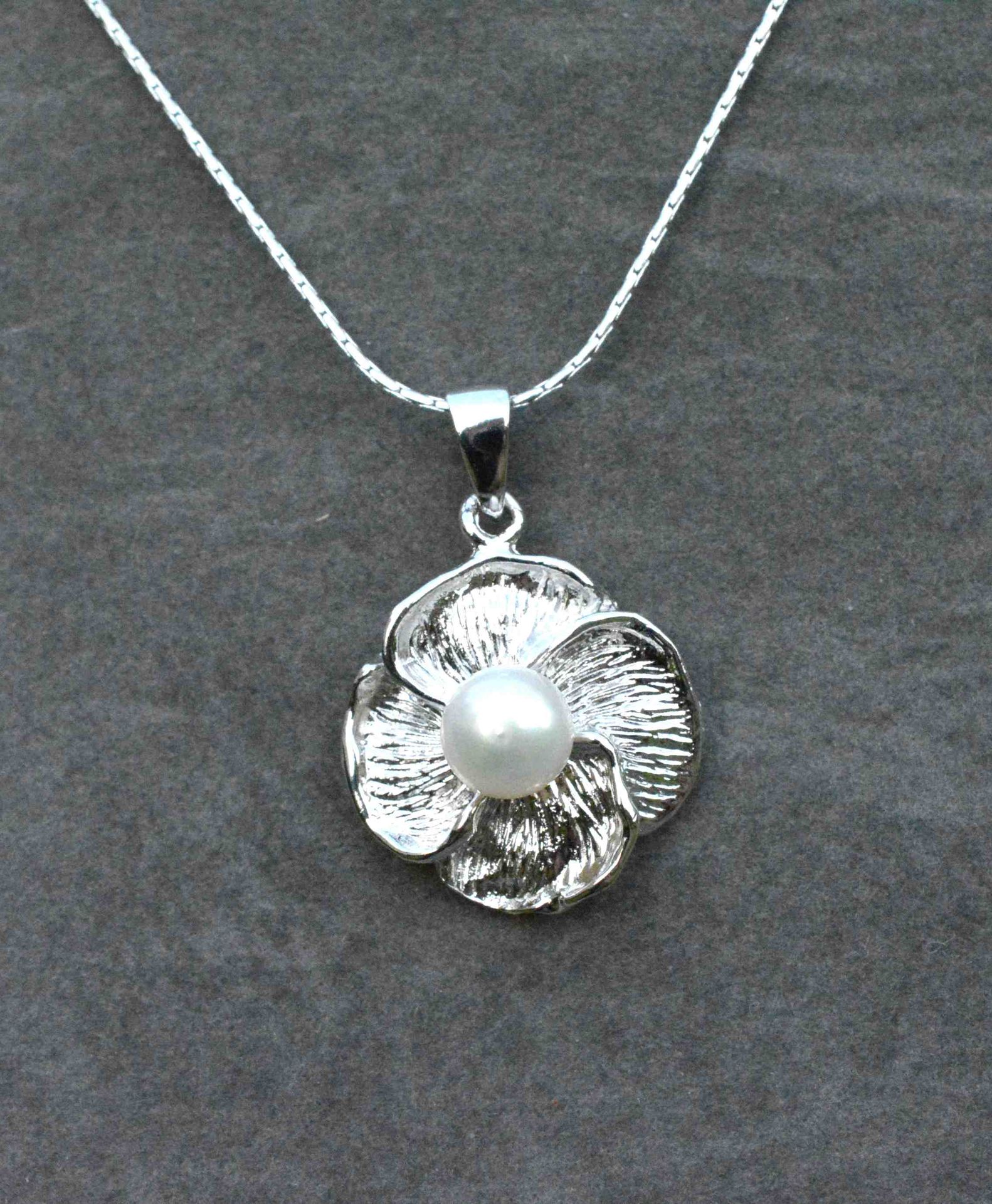 Null 原创吊坠，银链上的花瓣图案以一颗6-6.5毫米的天然养殖珍珠为中心。