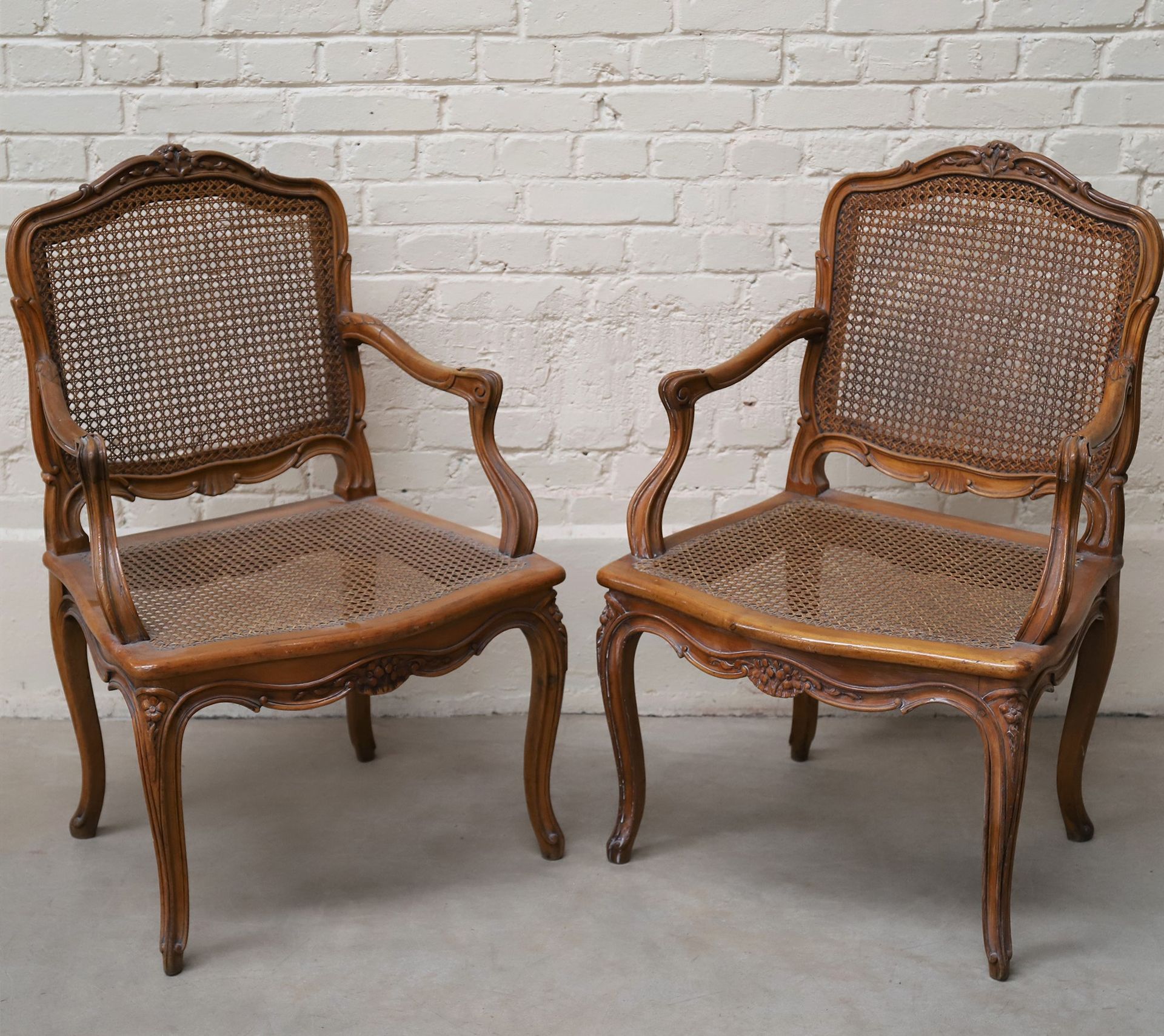 Null 一对轻型木制罐头椅，20世纪初

雕刻的花和叶子的装饰

直背、扶手和弧形腿

96.5 x 63.5 x 58.5厘米

使用和维护的条件