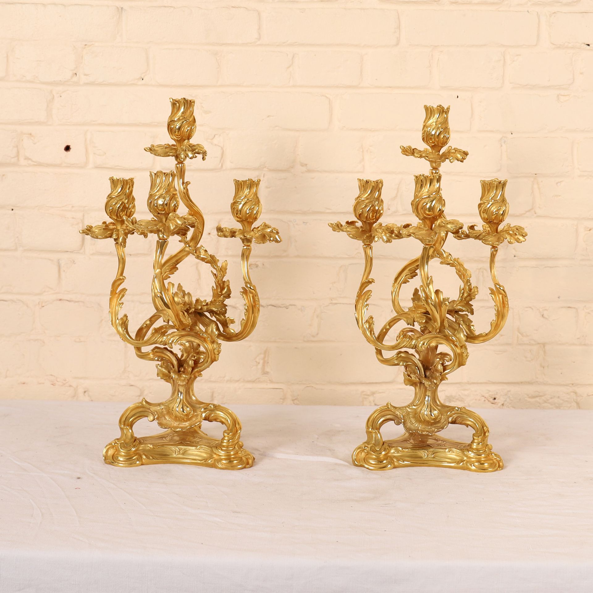 Null 一对路易十五风格的金质铜质烛台，卡菲利的模型

有四个灯臂和叶子的图案

19世纪晚期

高：48厘米

用于电气化的旧孔