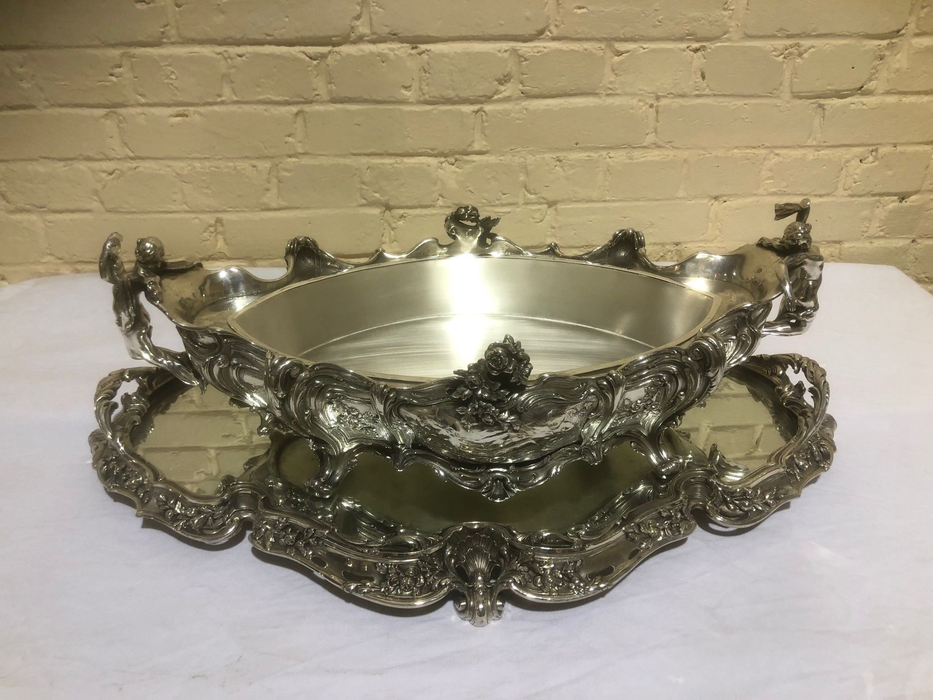 Null 路易十五的重要银色铜质餐桌中央装饰品
由一个中间的镜子组成的托盘，用来放置一个四脚花盆，花盆的把手是仿古风格的舞蹈人物造型。
用贝壳、花和植物作装饰
&hellip;