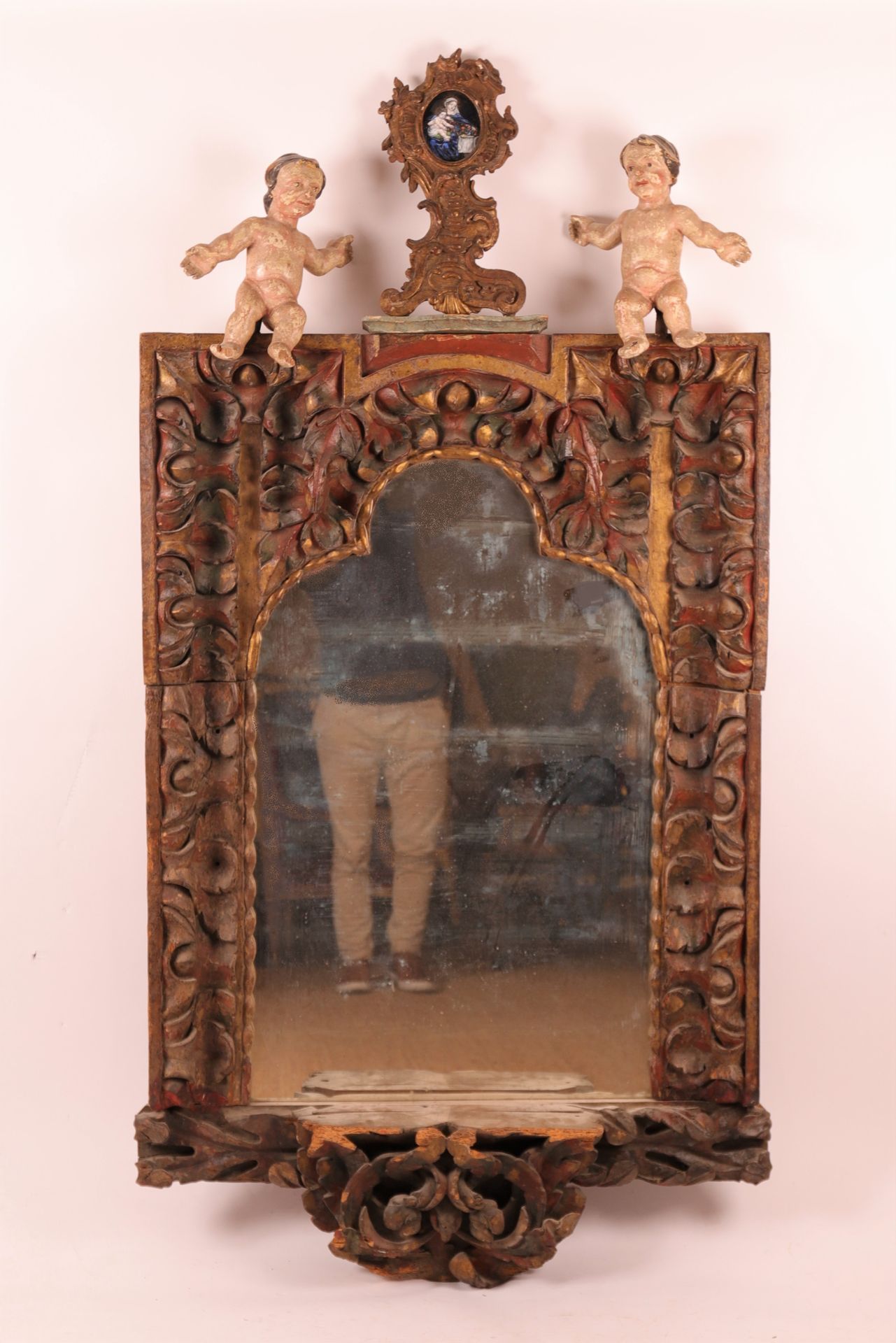 Null 大型意大利雕花木镜，18世纪
带镀金的多色木雕，下部有一个展示架
三棱镜，上面有一个路易十五风格的门楣，上面有一个珐琅质的 "带水果篮的圣母和儿童"，&hellip;