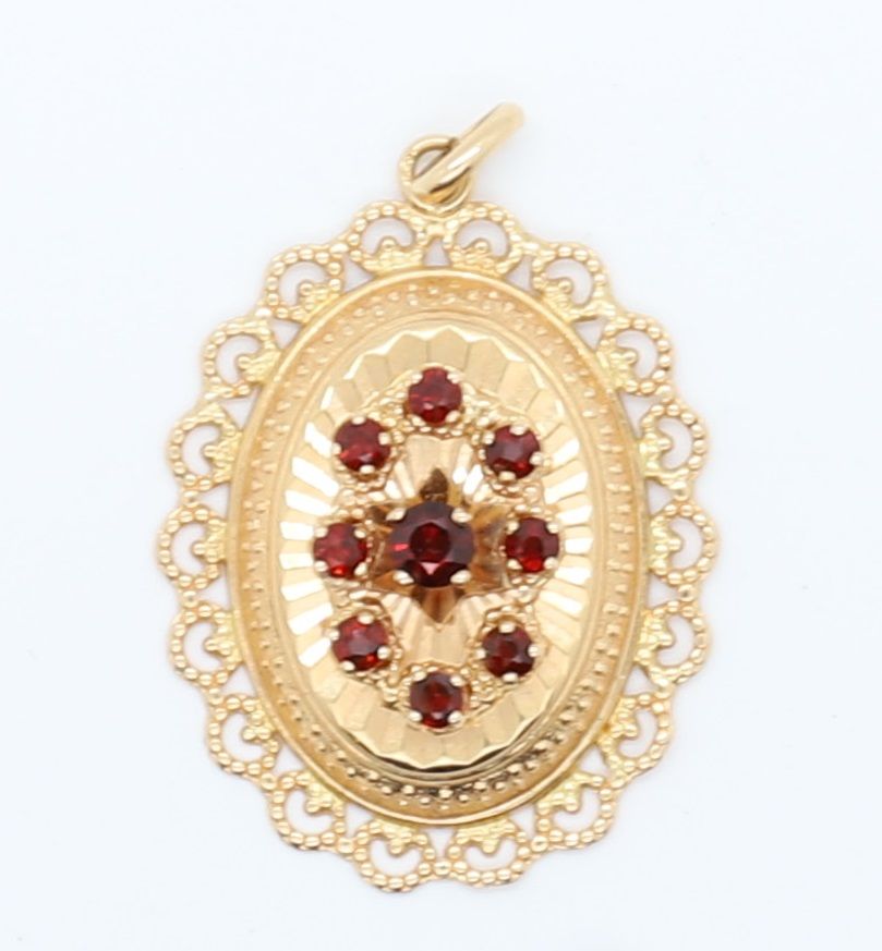 Null 可爱的黄金吊坠与小红石 
0.20克拉的中央宝石，周围有八个小宝石
34 x 26毫米（不含扣）。
重量 : 4,8 grs