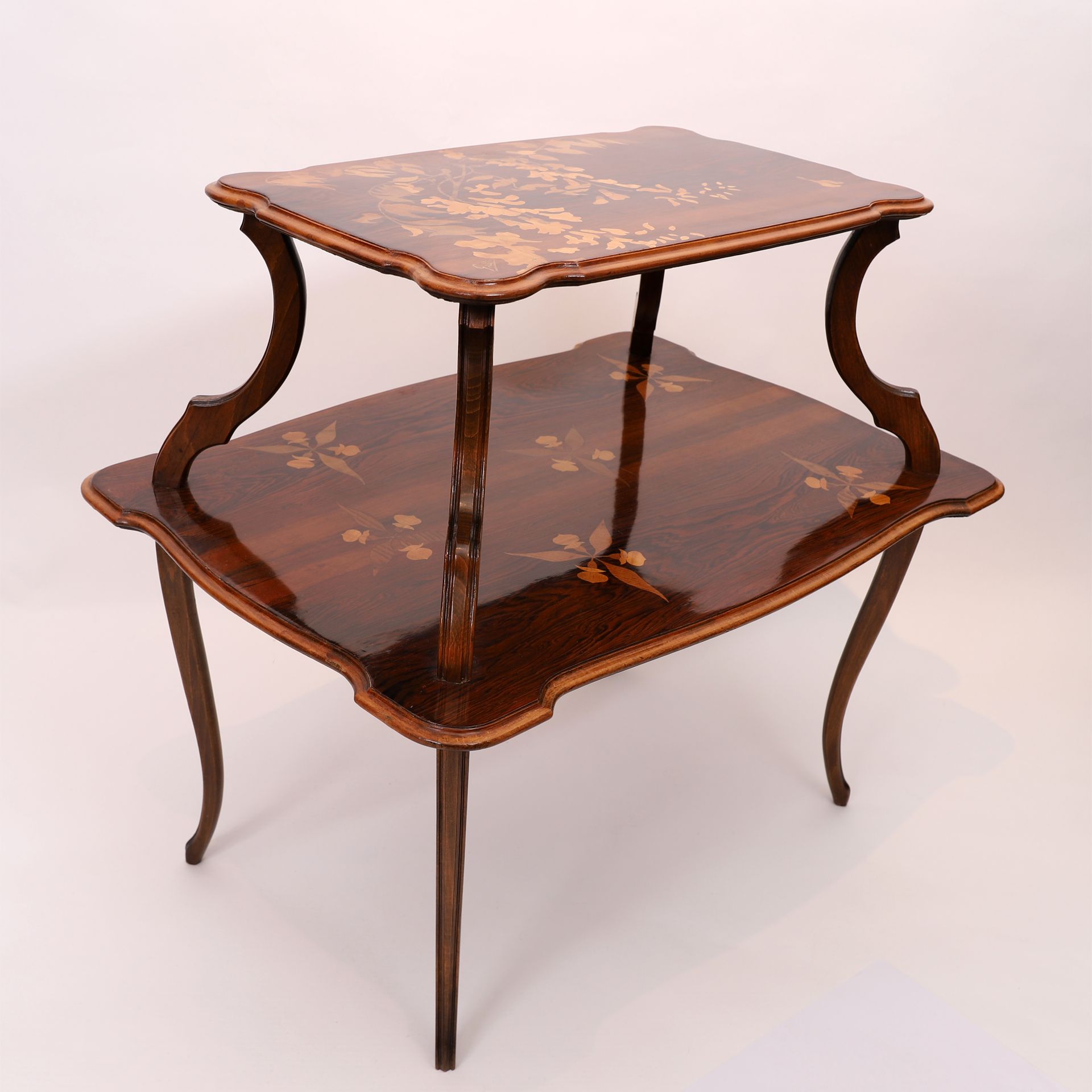 Null 埃米尔-加莱（1846-1904 年）制作的非常精美的双层茶几
茶几立于四条弧形模制桌腿上，桌面边缘模制。
用各种木材镶嵌装饰，顶部饰有紫藤花，隔板上&hellip;