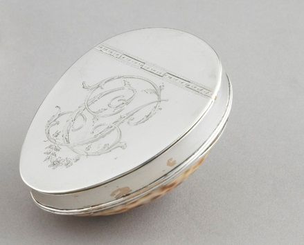 Null 
一个银制的鼻烟盒。 

伦敦18世纪末-19世纪初。 

银器大师：托马斯-菲普斯和爱德华-罗宾逊。 

外壳（瓷器）有一个银色的铰链盖，上面刻有一&hellip;