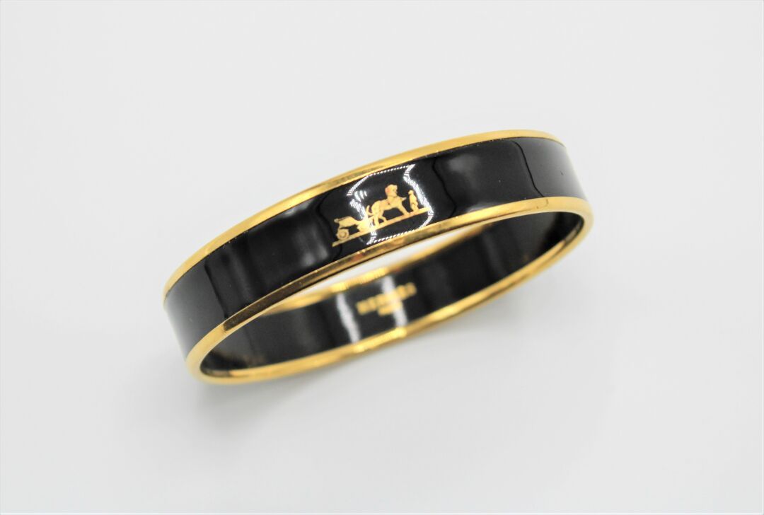 Null HERMES. 
Bracelet "Calèche" in gilded metal enamelled black. 
Width: 1.5cm,&hellip;