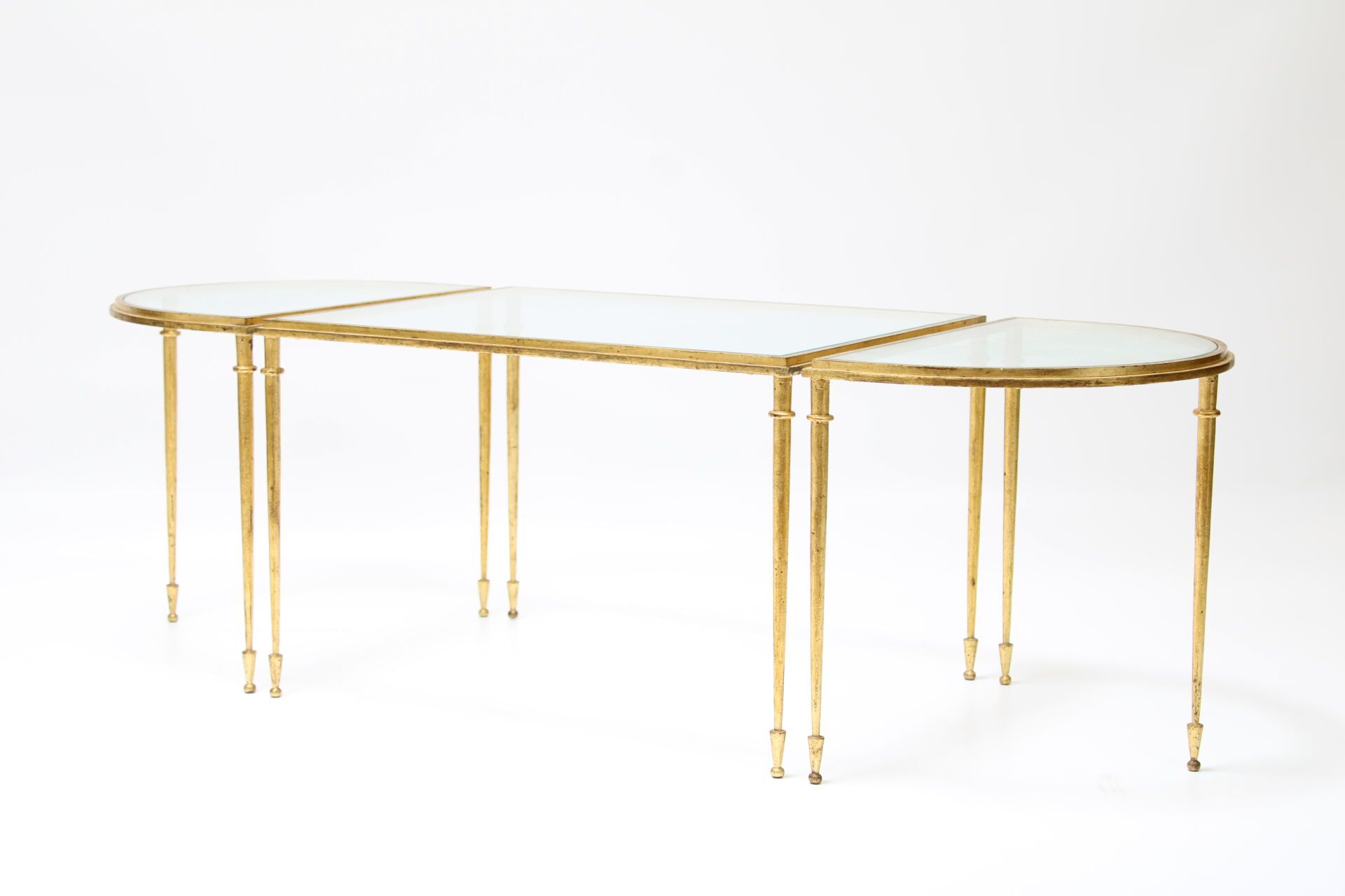 Null 罗杰-蒂比尔（1926-2001）。
由三部分组成的咖啡桌，镀金青铜框架和玻璃桌面。已签名。
中央桌尺寸：39x60x47 厘米。边桌尺寸：39x47&hellip;