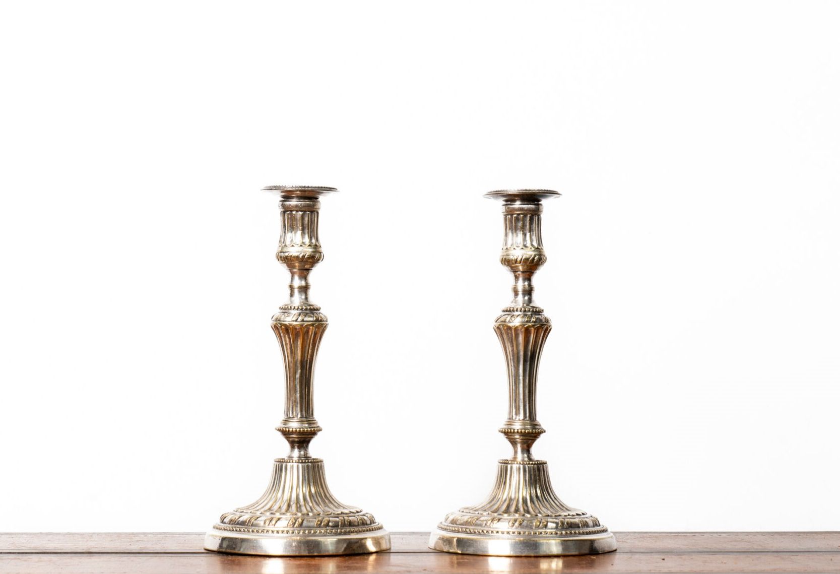 Null 一对带烛台的镀银烛台，饰有楞纹和珍珠。路易十六时期。 
高度：27 厘米 
现状：一只脚凹陷