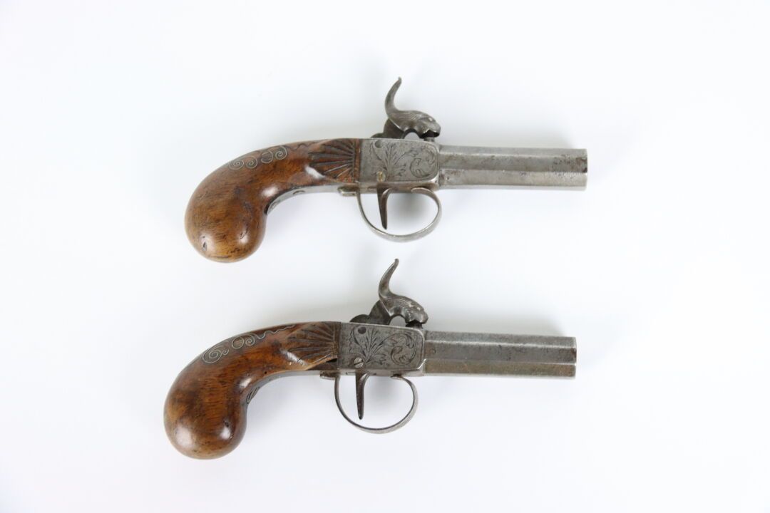 Null 一对打击式手枪，胡桃木的枪托上镶嵌着金属卷轴和雕刻着风格化的贝壳，枪锁上雕刻着叶子的图案。变形的猎犬和枪管。19世纪。长度: