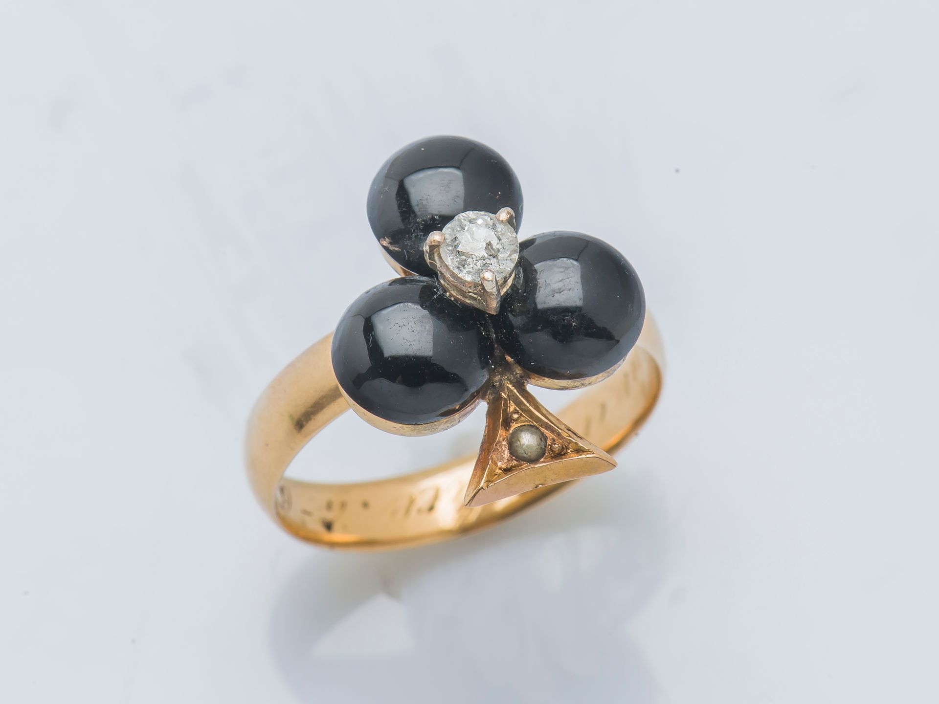 Null 一枚18K黄金（750‰）三叶形戒指，镶嵌有三颗凸圆形玛瑙，中间有一颗钻石，戒指上刻有周年纪念日。

手指大小：58 总重量：4.8克