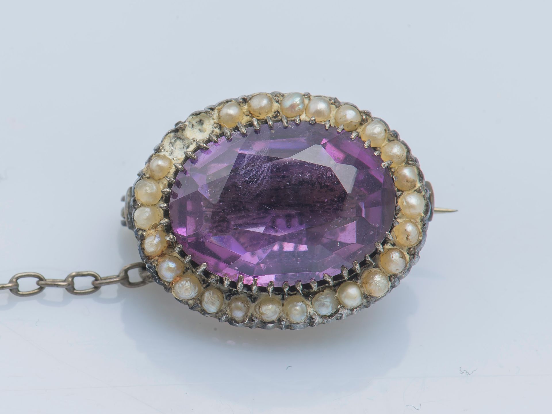 Null 一枚银质胸针（800‰），上面装饰着一颗椭圆形的紫水晶，周围有珍珠种子（缺失）。19世纪。

宽度 : 2 cm 毛重 : 4,8 g