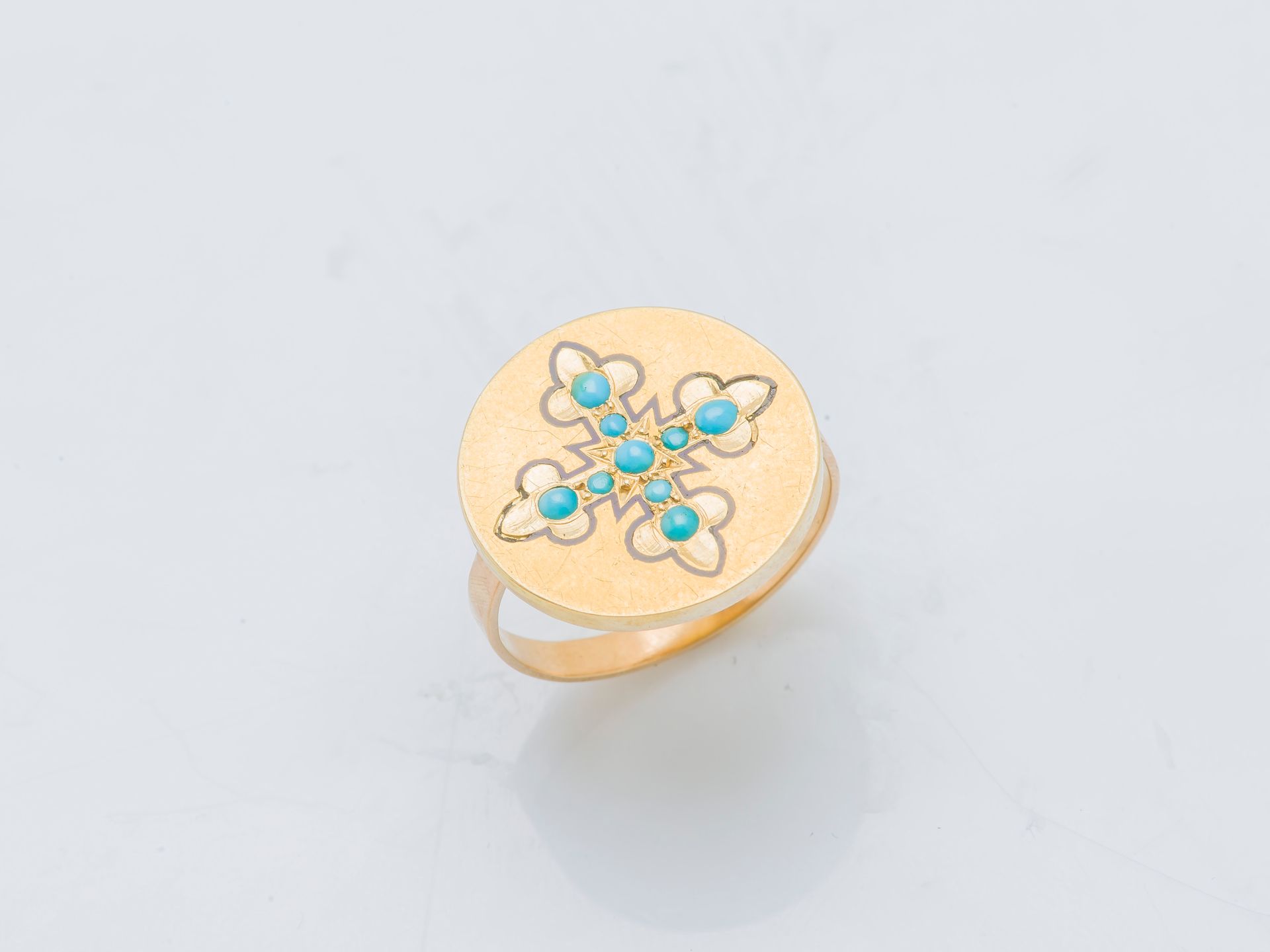 Null Ein Ring aus 18 Karat (750 ‰) Gelbgold, dessen runde Lünette mit einem Lili&hellip;