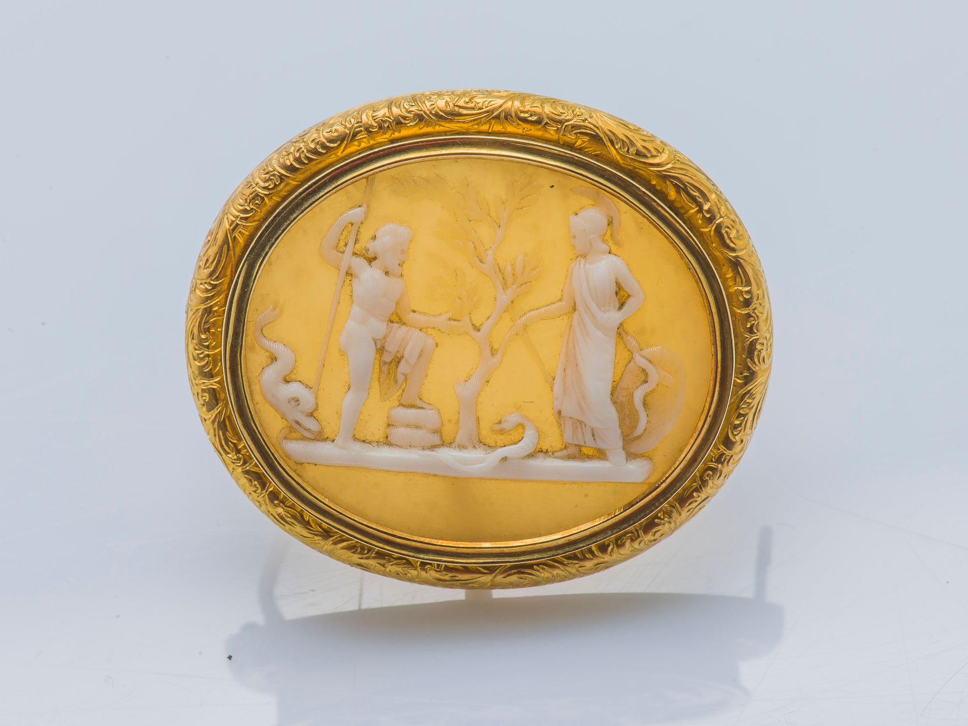 Null 
一枚18克拉（750 ‰）的黄金胸针，镶嵌着贝壳浮雕，装饰着一个神话场景，描绘着一个战士和一个牧羊人在花园里，并点缀着两条蛇和一条海豚。法国作品，金&hellip;