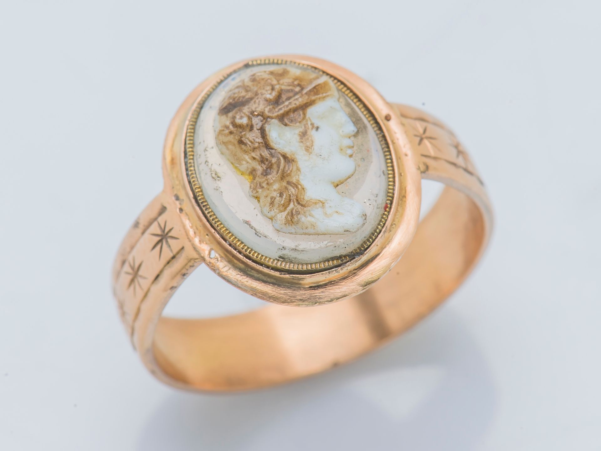Null 一枚18K（750‰）黄金戒指，镶嵌着玛瑙上的浮雕，描绘着一个年轻人的轮廓，平坦的戒指上追逐着星星。

手指大小：毛重：5.1克