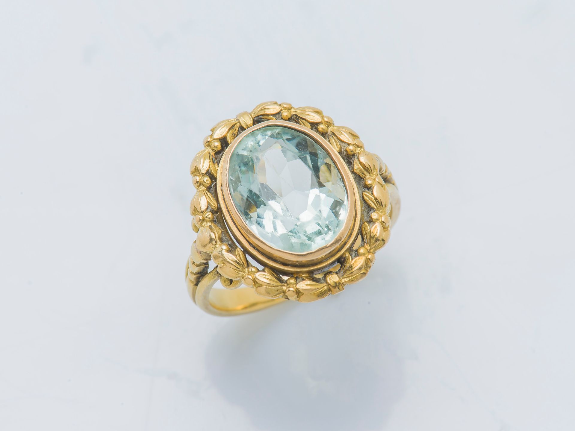 Null 一枚18K（750‰）黄金戒指，镶嵌着一颗重约3.7克拉的椭圆形海蓝宝石，周围有月桂花纹，肩部有珍珠装饰。法国作品，19世纪。

手指大小：51 总重&hellip;