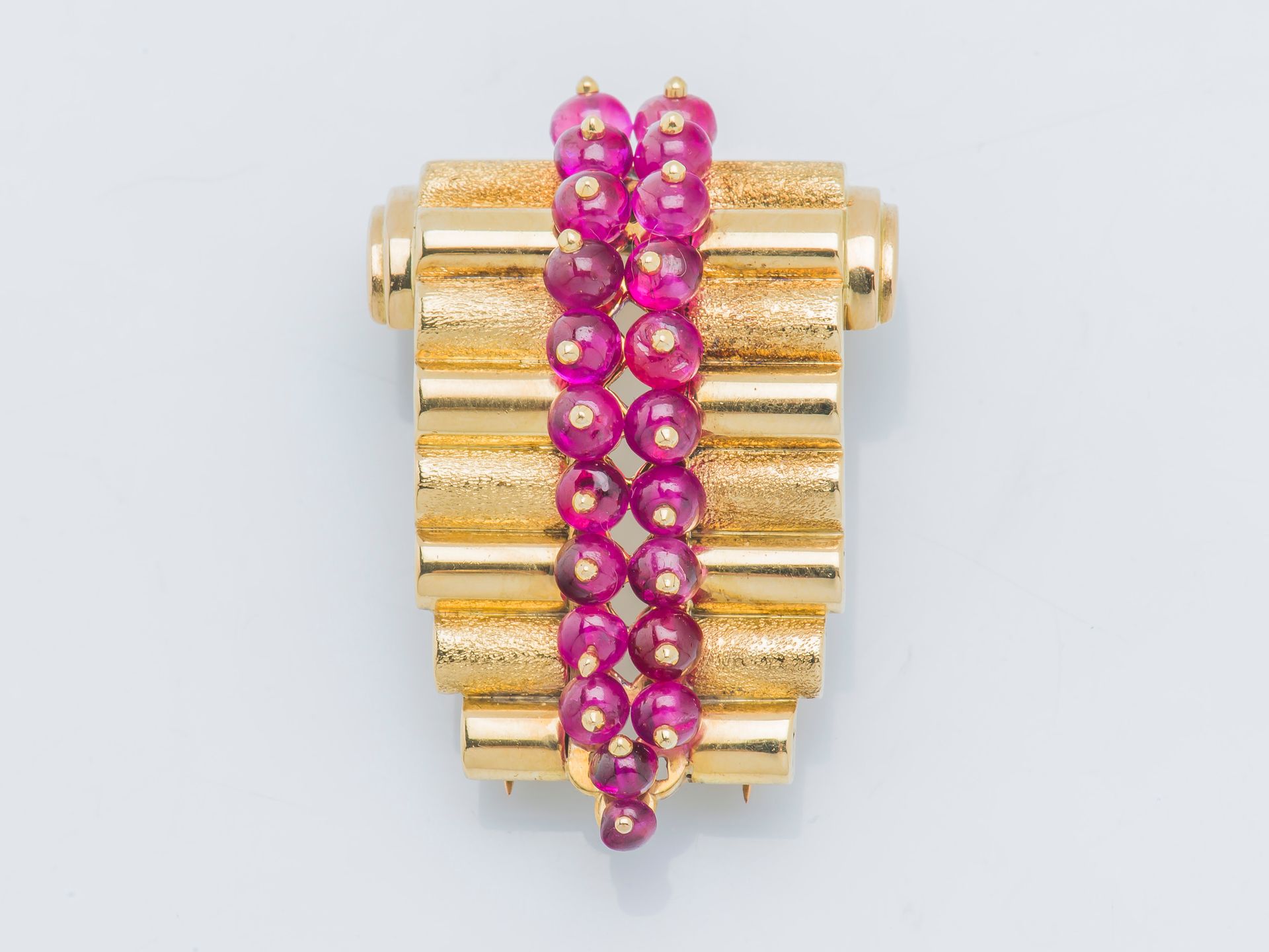 René BOIVIN (1938-1945) 一枚18克拉（750‰）的黄金领夹胸针，设计了一个宝石扣，纹理和光滑的宝石交替出现，中间镶嵌着簇状的红宝石珠子。&hellip;