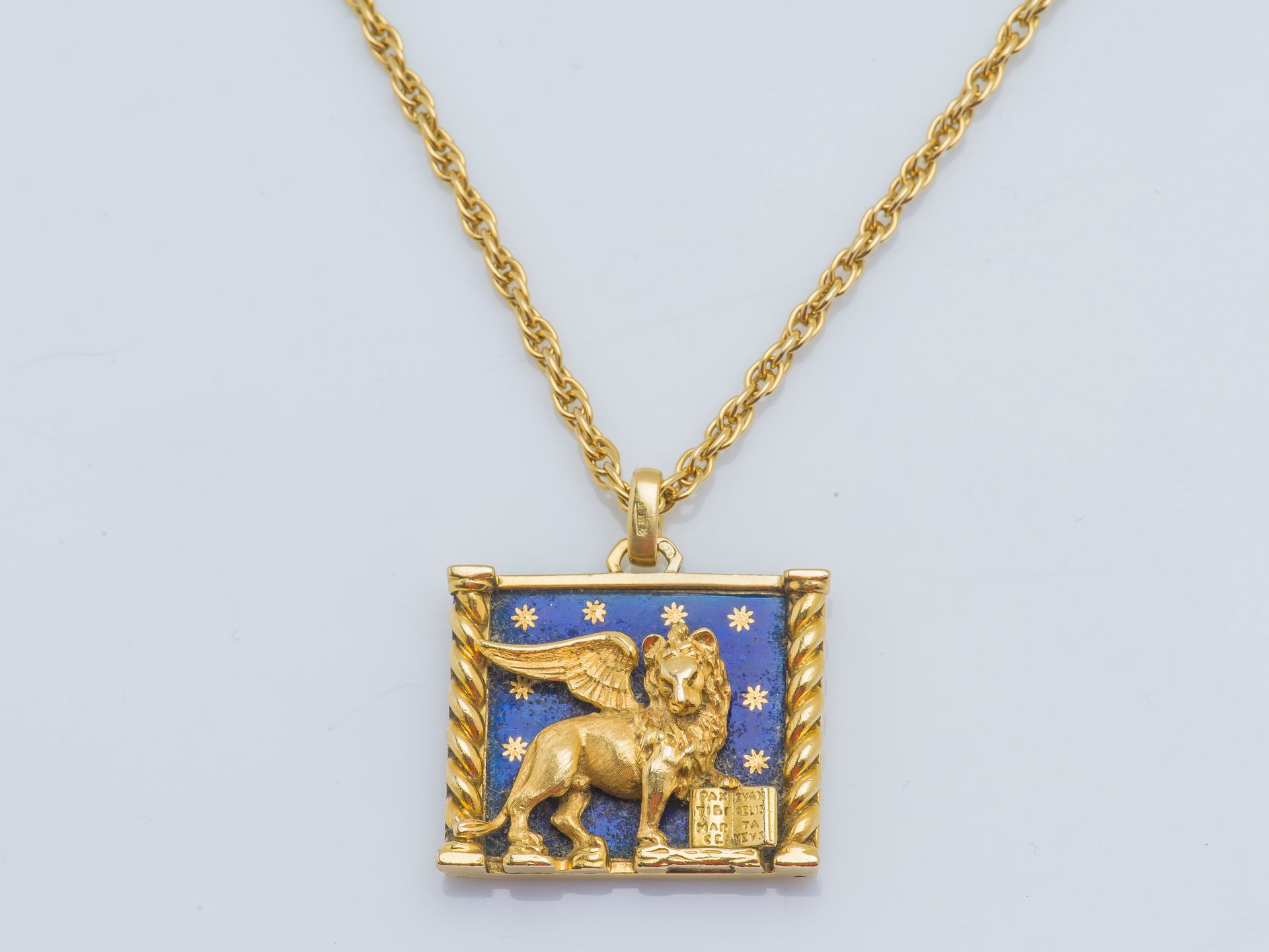 Null 一条18克拉（750‰）的黄金绳链和吊坠，上面有一个长方形的吊坠，在蓝色到半星形的珐琅背景上描绘着圣马克的狮子。法国的工作。

颈部长度：80厘米 总&hellip;