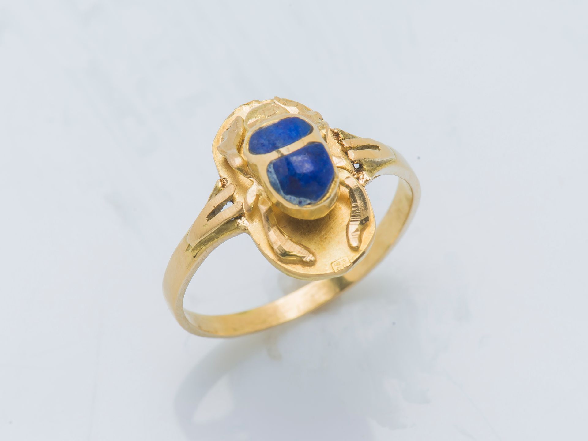 Null 一枚18K（750‰）黄金戒指，装饰有皇家蓝色珐琅的浮雕石斑，背面有一个手绘的象形文字。

手指大小 : 52 毛重 : 2,3 g