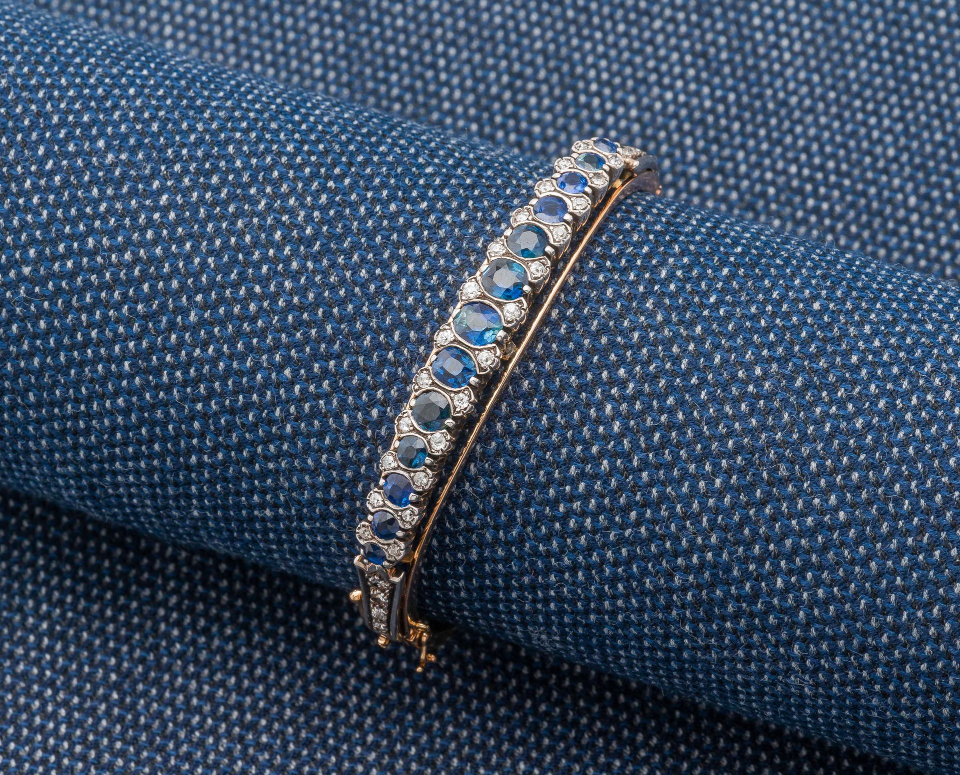 Null 18K（750 ‰）白金镂空手镯，镶嵌着一排弯曲的椭圆形和圆形蓝宝石以及小型老式切割钻石。法国作品，19世纪末。

直径：5.5厘米 毛重：22.1克