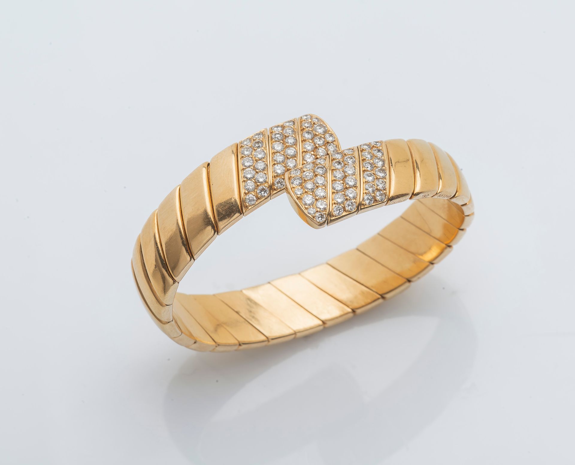 CARTIER 一条18K黄金（750 ‰）的开放和灵活的扁平手链，有一个扭曲的平坦的加德隆设计，两端镶嵌着明亮式切割钻石。有签名和编号的。

直径：5.5厘米&hellip;