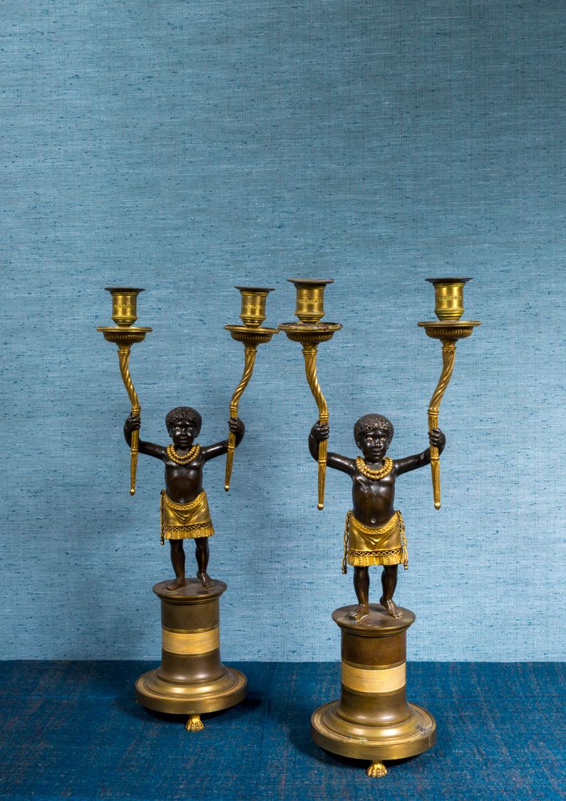 Null 一对三足鼎立的烛台，有两个铜锈和鎏金的铜臂，描绘了两个年轻的努比亚人站在鼓形的底座上。

复原期

高：48厘米

腰带上少了一条绳子

安托万-莱斯&hellip;