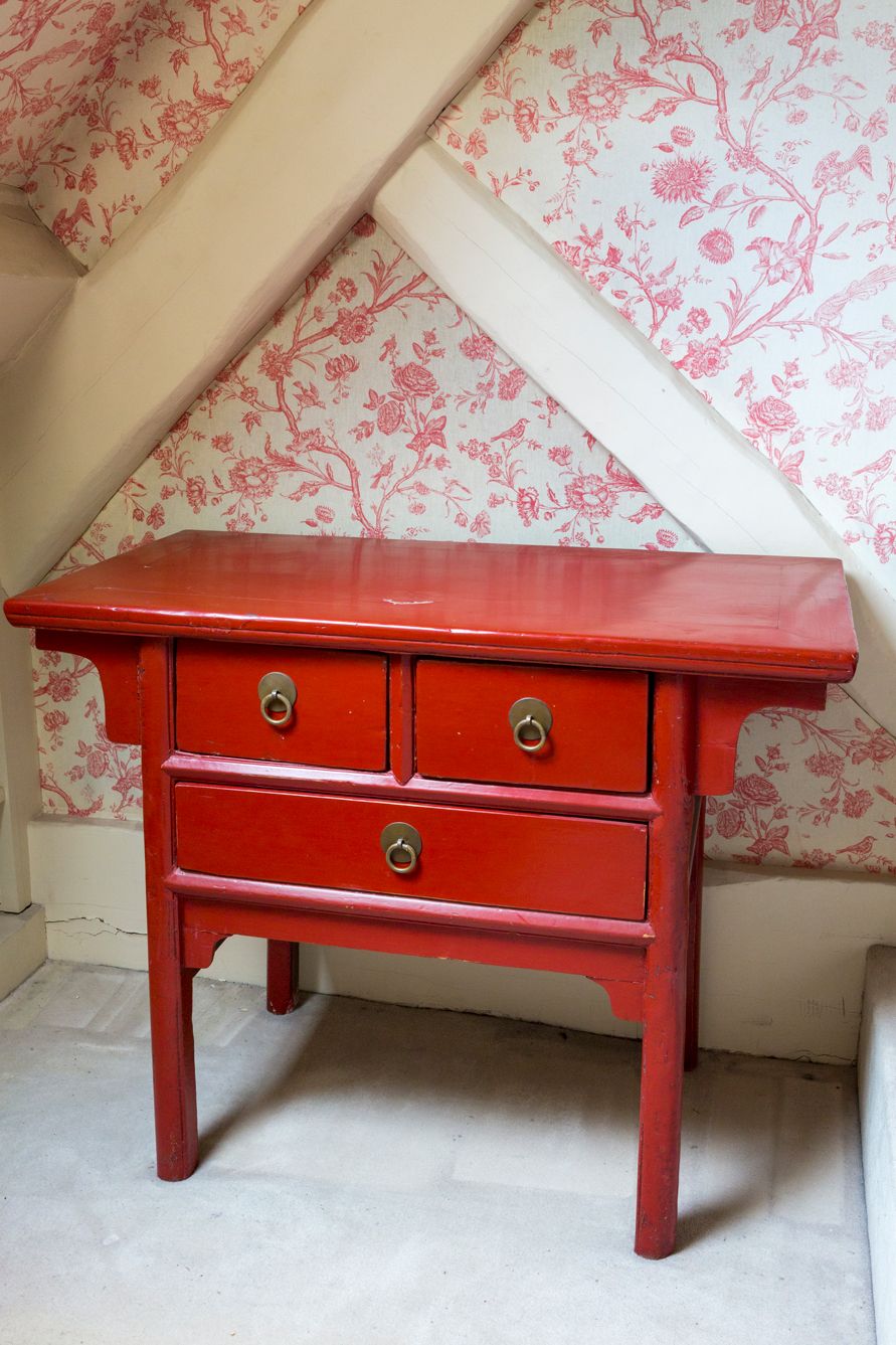 Null Rot lackierter Holztisch, der durch drei Schubladen geöffnet werden kann.

&hellip;