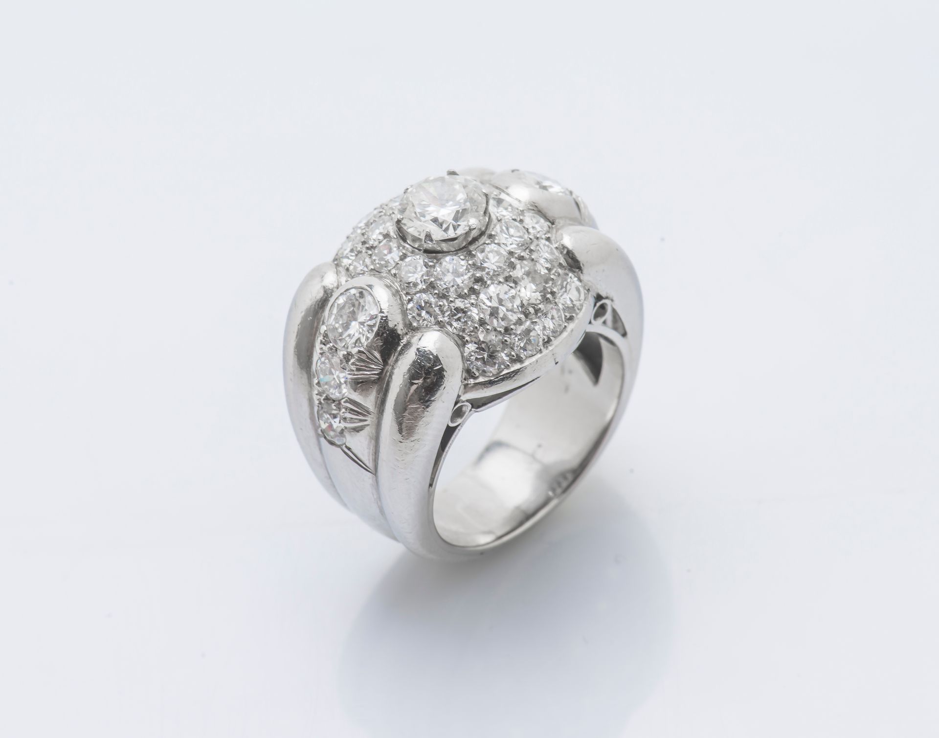 Null 铂金（950‰）桥形戒指，形成一个圆顶，镶嵌着一颗明亮型切割钻石，重约0.70克拉，周围是较小的明亮型切割钻石和石榴石。约1935年的法国作品，金匠印&hellip;