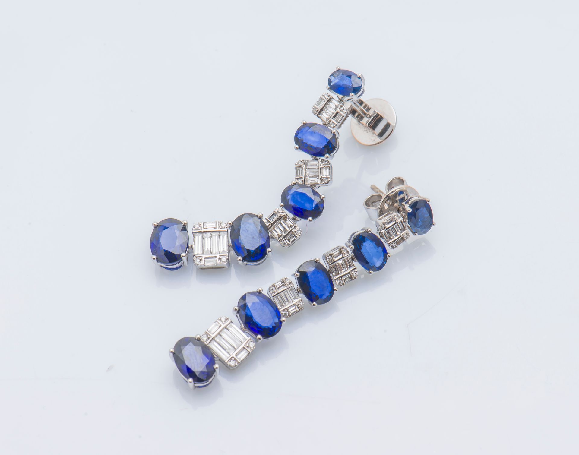 Null 一对18ct (750 ‰)白金耳环，镶有五颗坠落的椭圆形蓝宝石，与镶嵌长方形和圆形钻石的长方形图案交替。蓝宝石的总重量约为10克拉。

长度：5厘米&hellip;