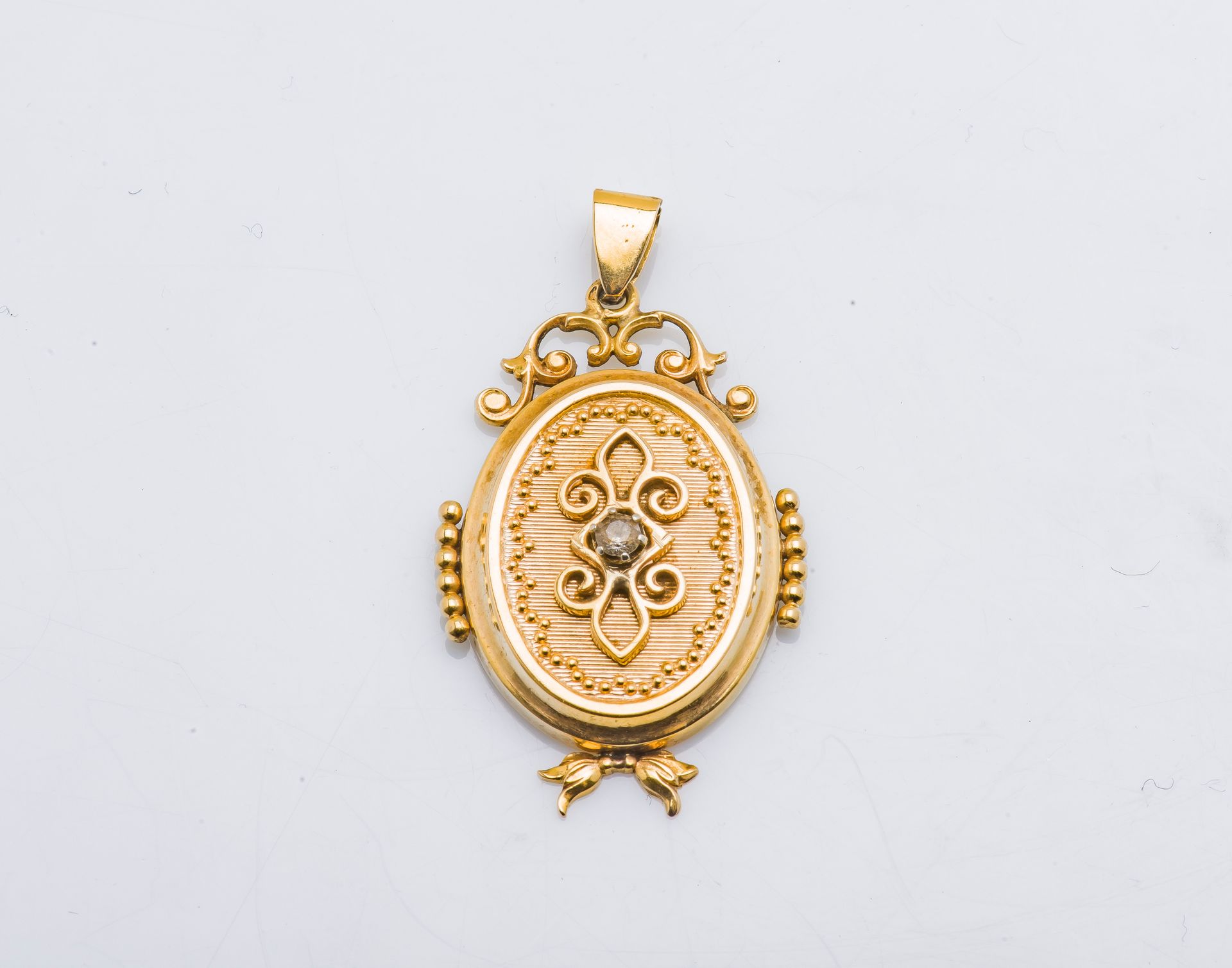 Null 
18K黄金（千分之七十五）的奖章吊坠，镶嵌着一颗白色的石头，上面有鏤空和珍珠装饰。




高度 : 4,5 cm 毛重 : 7,1 g

法律费用&hellip;