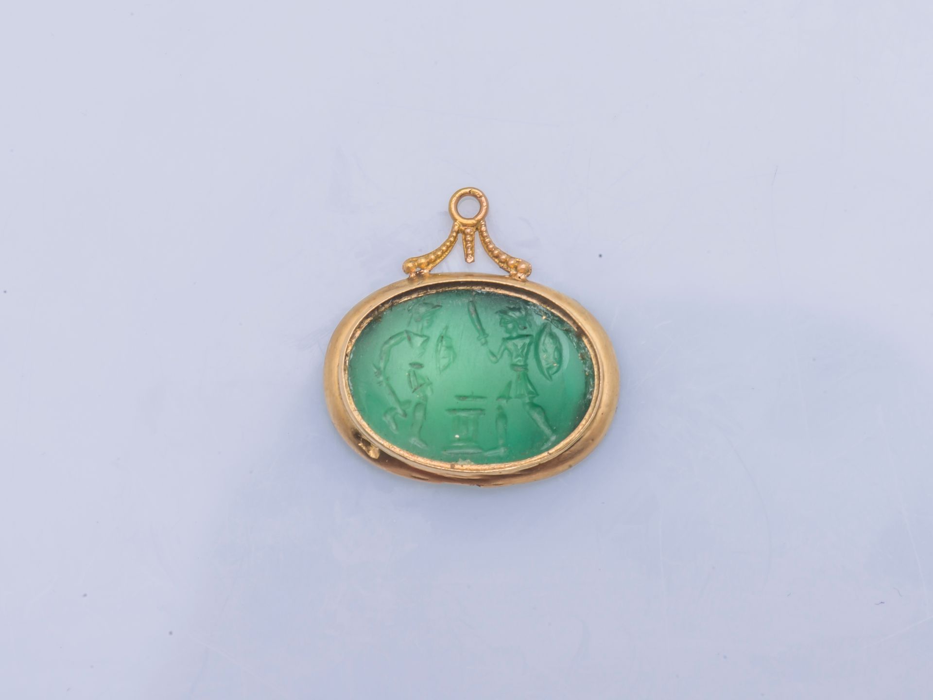 Null 18克拉黄金（千分之七十五）的椭圆形吊坠，镶嵌着刻有决斗场景的绿色玻璃膏（旧表钥匙，转变和缺失的部分）。

高度：2,3 cm 长度：2,3 cm 总&hellip;