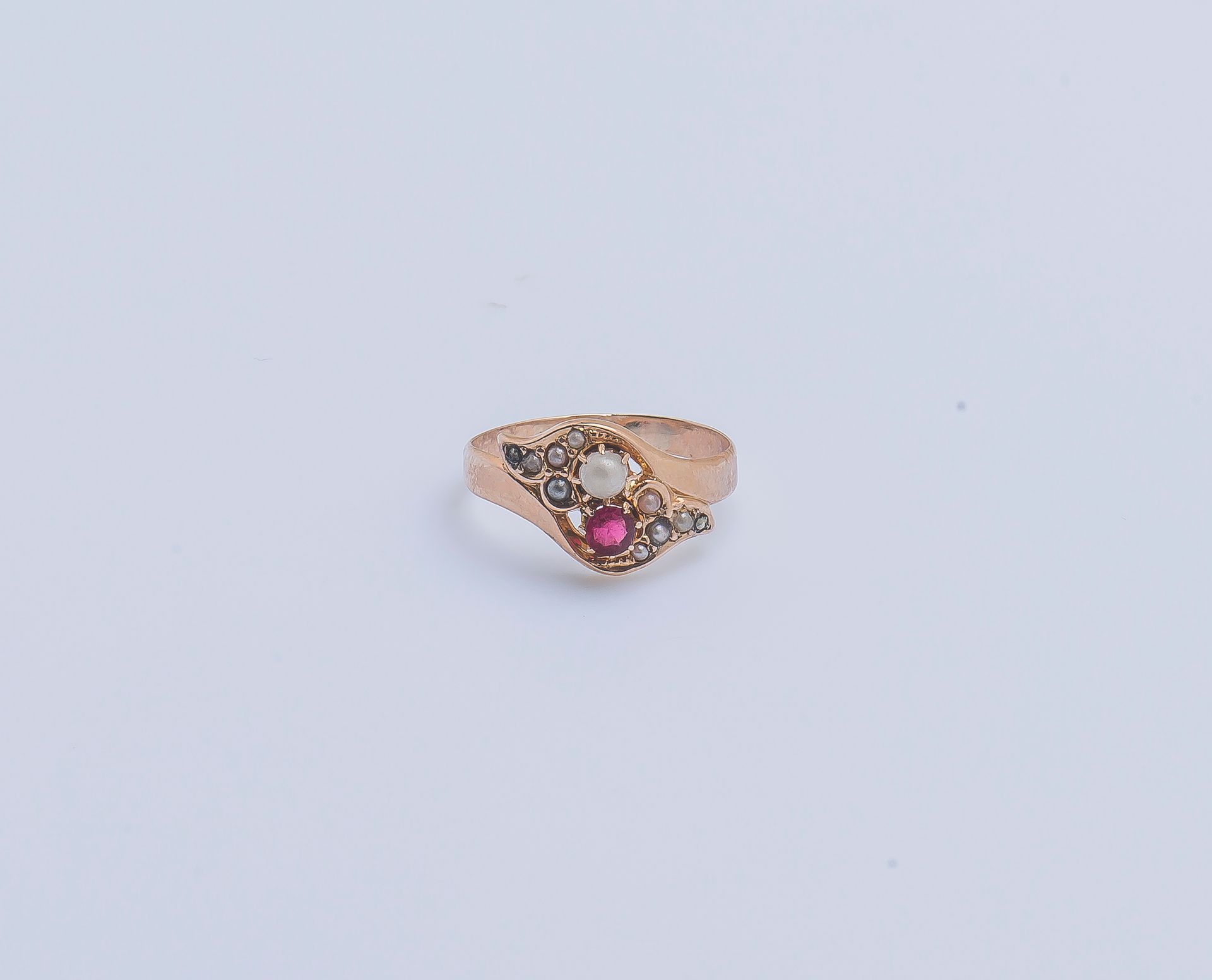 Null 一枚18K（750‰）玫瑰金带状戒指，镶嵌有花式半珍珠和红宝石，肩部有两朵镶嵌珍珠种子的百合花图案。法国作品，南希1838-1892。

手指大小：5&hellip;