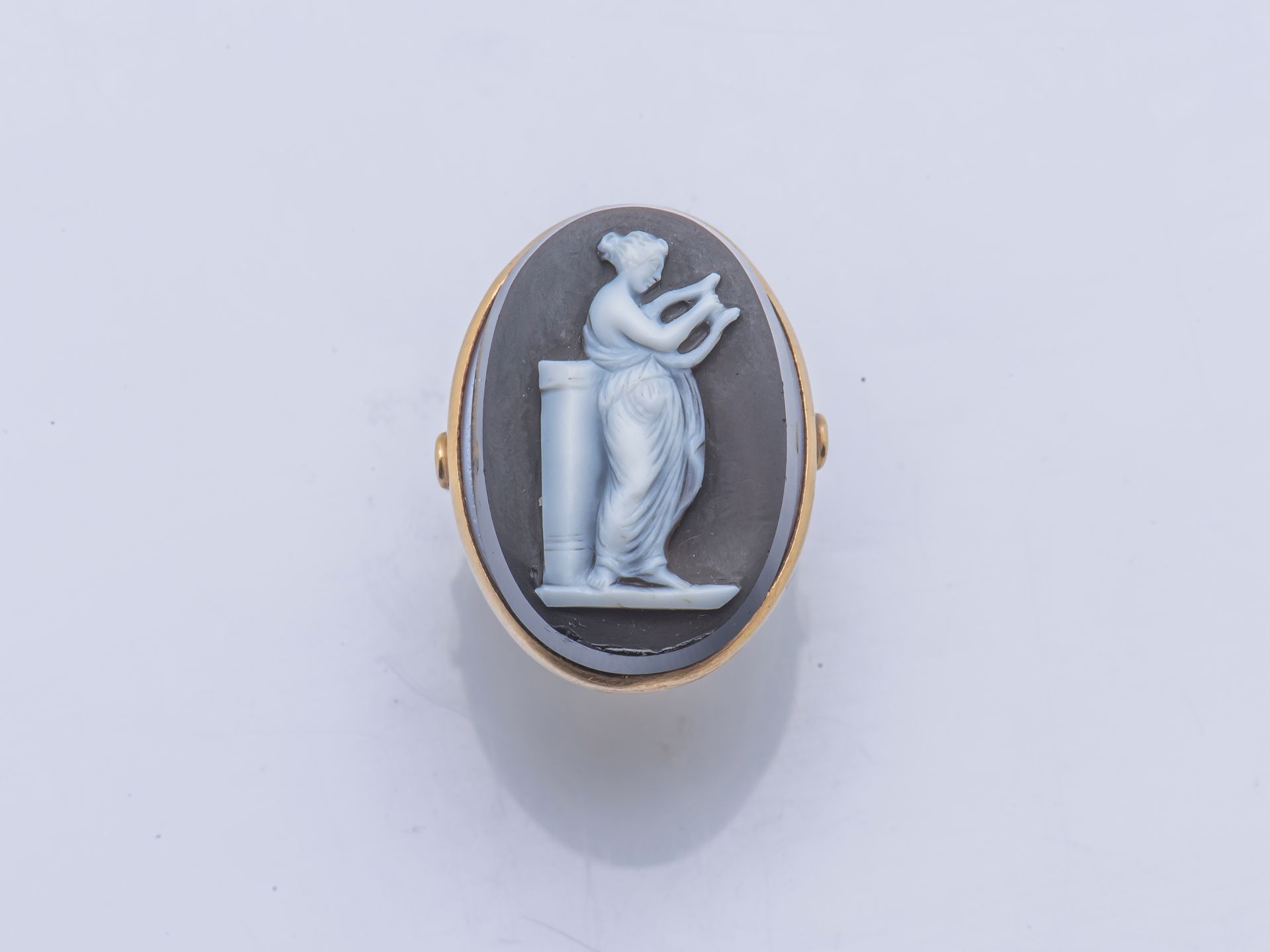 Null 18克拉（750千分之一）黄金戒指，镶嵌有玛瑙浮雕，代表一个站立的女人在弹琴。

手指尺寸 : 52 / 53 毛重 : 14,4 g