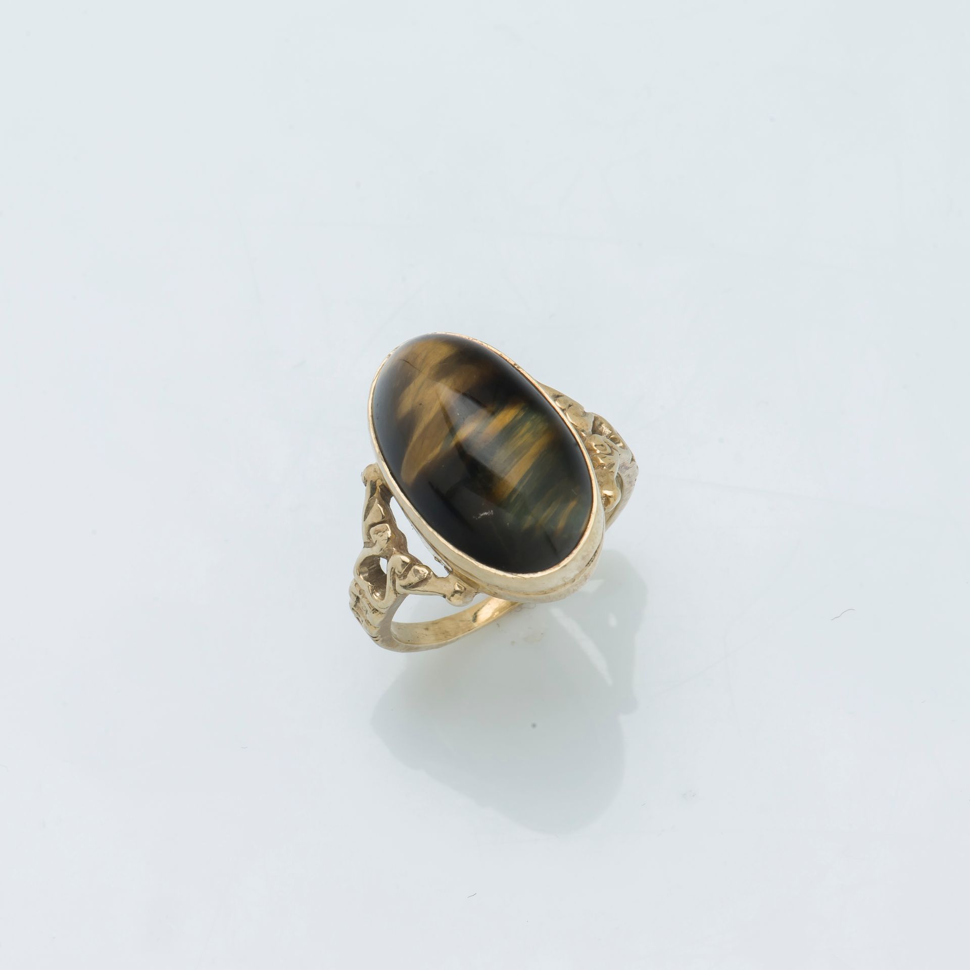 Null 一枚9K黄金戒指（375 ‰），镶嵌着凸圆形鹰眼石，戒指的肩部有镂空装饰。

手指大小：52 总重量：5.1克