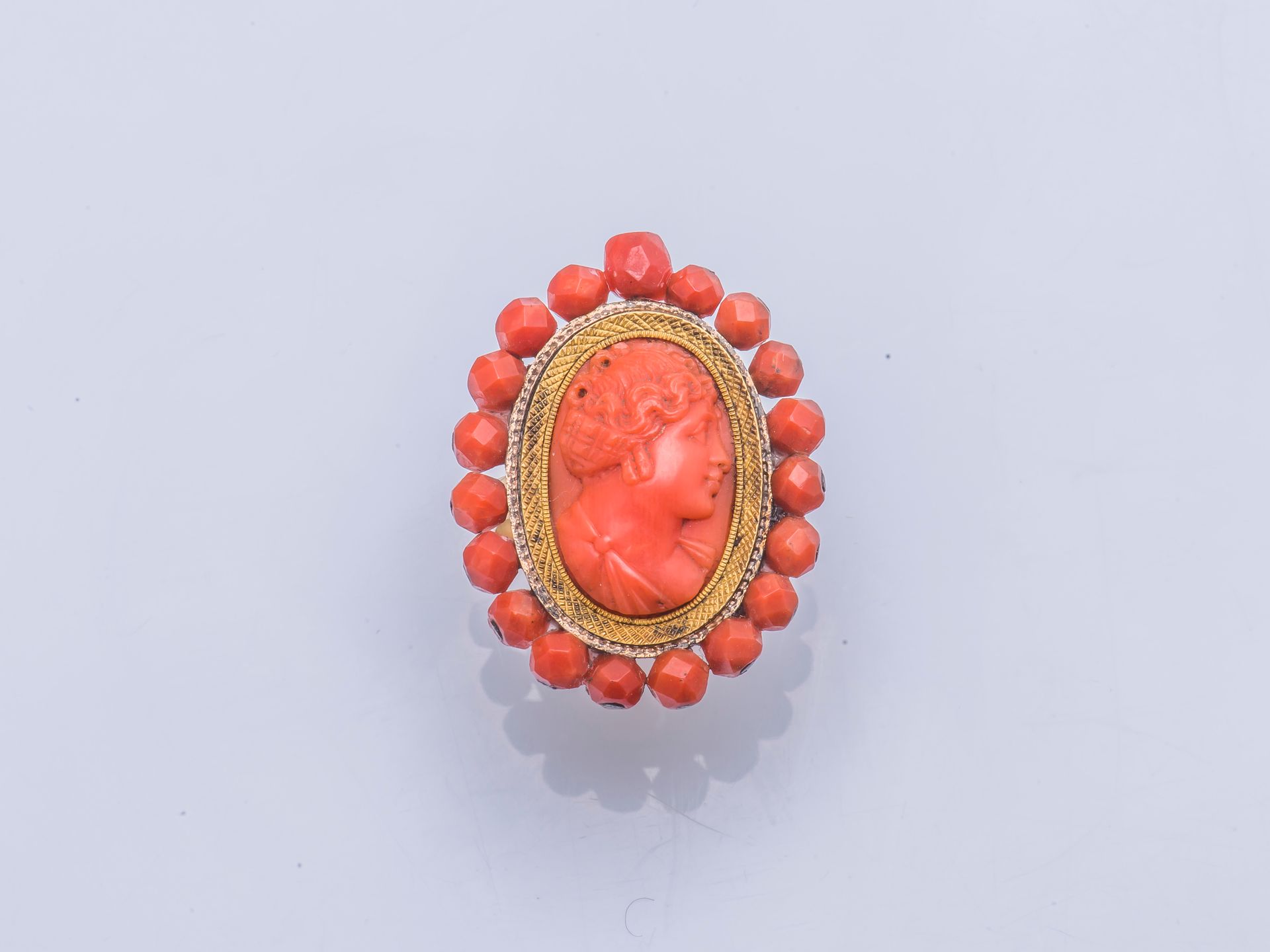 Null 黄金戒指18克拉（千分之七十五），装饰有珊瑚（珊瑚属，CITES附录II B公约前）浮雕，表现了一个女性的轮廓，周围有刻面的珊瑚球。(将胸针变成戒指)&hellip;